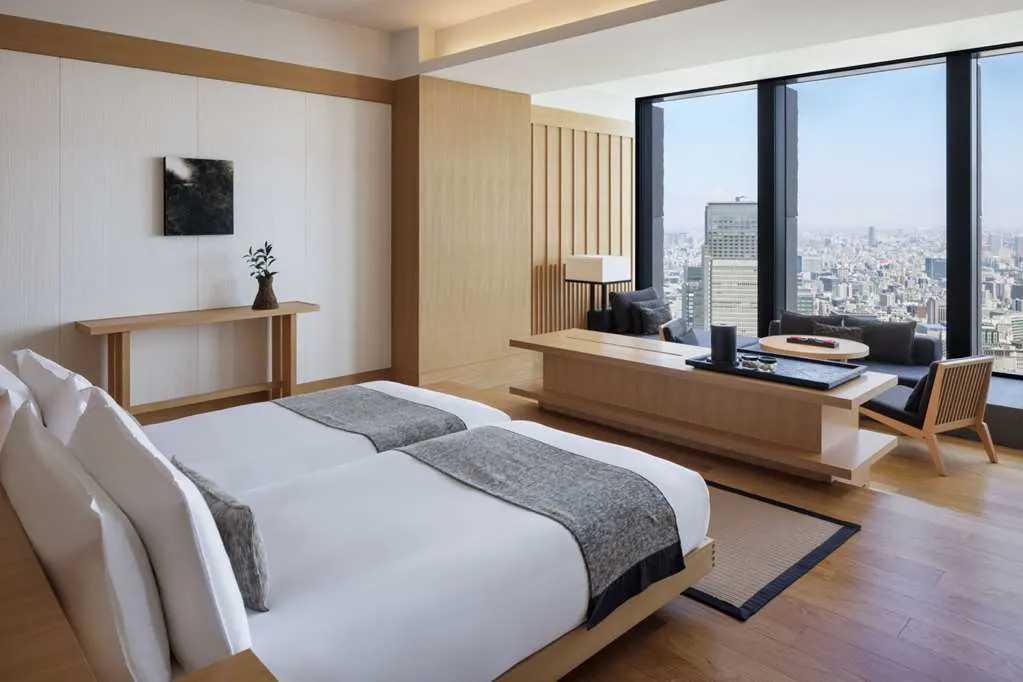 a sleek, minimalist hotel room with floor-to-ceiling windows overlooking a city