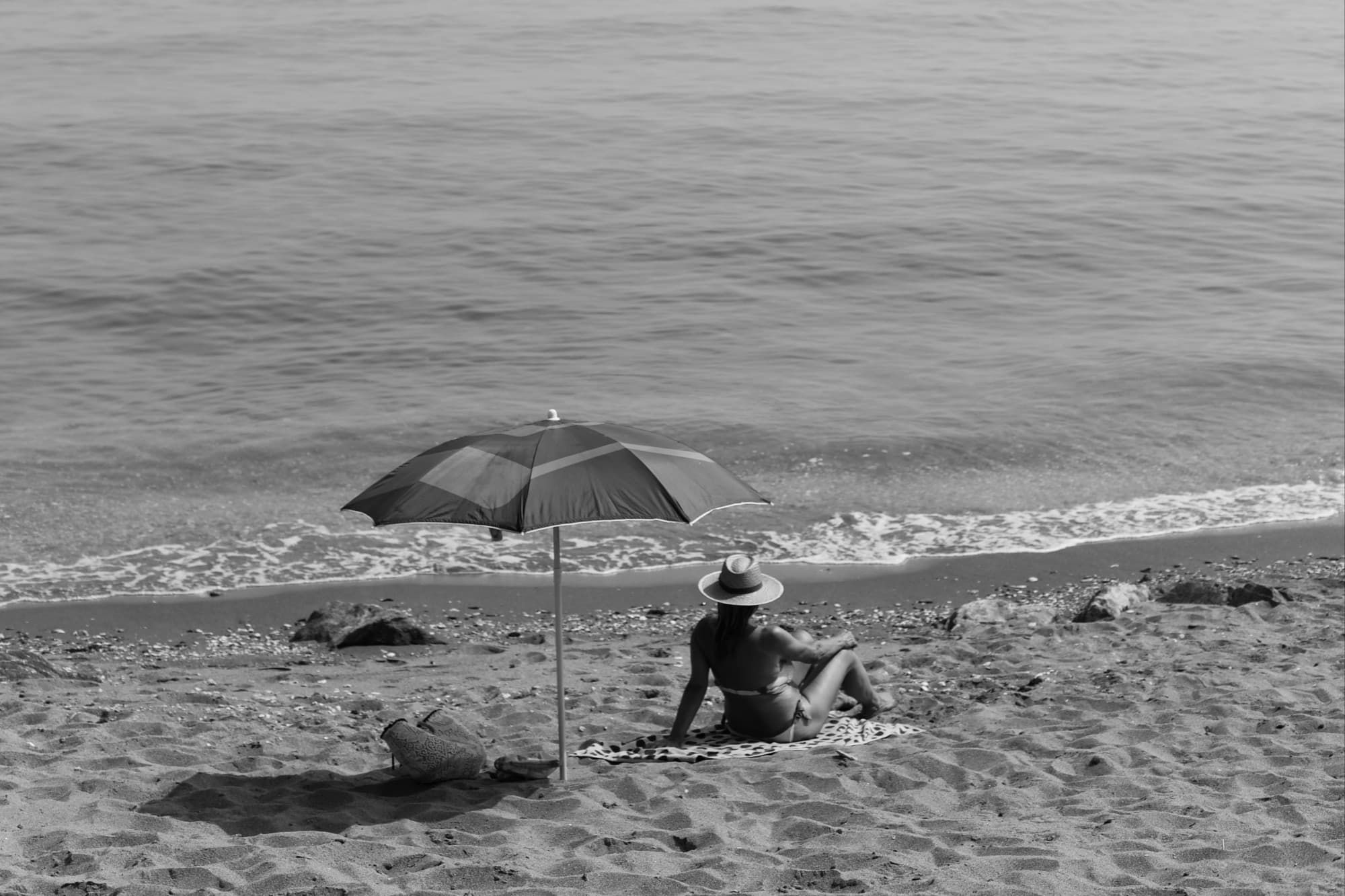 black-and-white photo of a woman lounging on a beach
