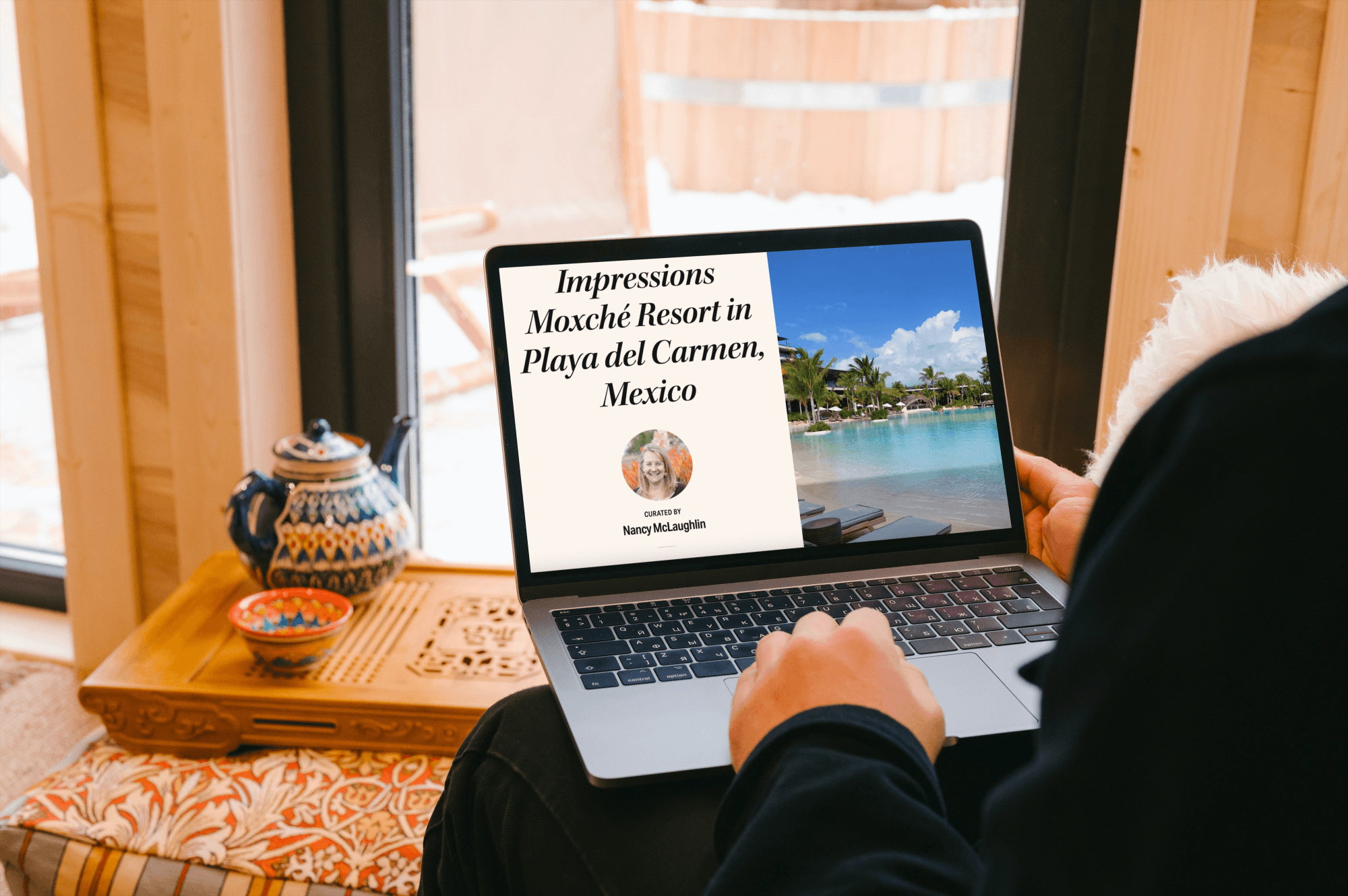 A woman on her laptop near a pot of tea