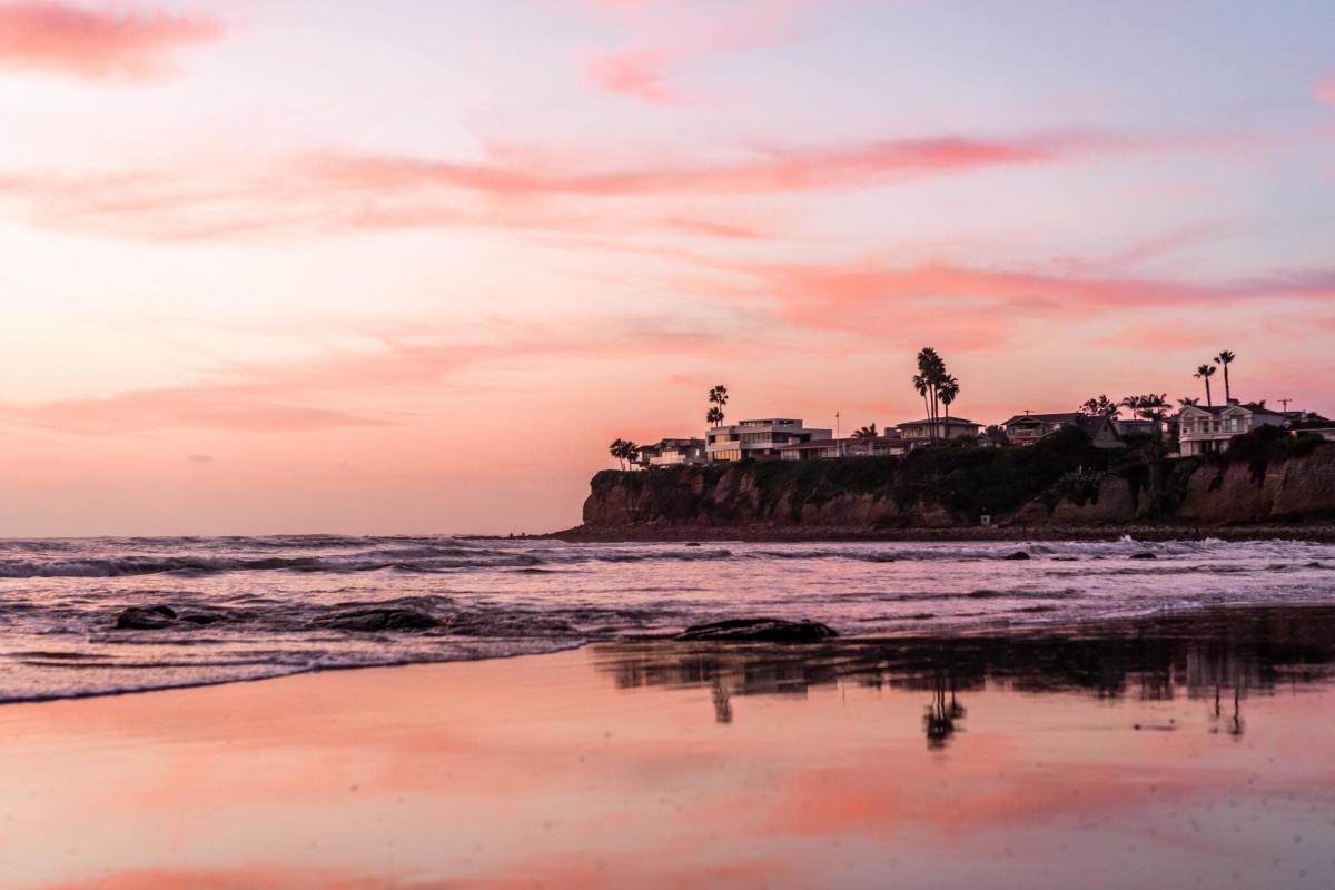 Beach and shore reflecting pastel sunset in San Diego.