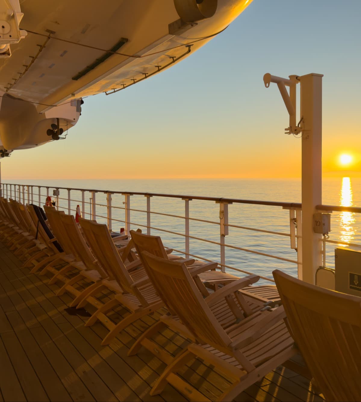 A view from the ship deck overlooking the ocean at sunset.