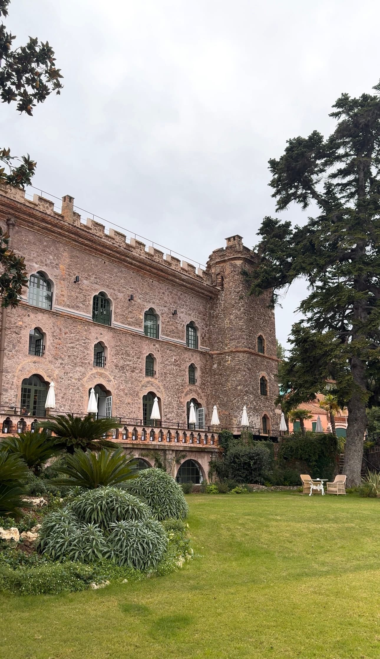 Outside view of a castle-like building next to a lawn during the daytime