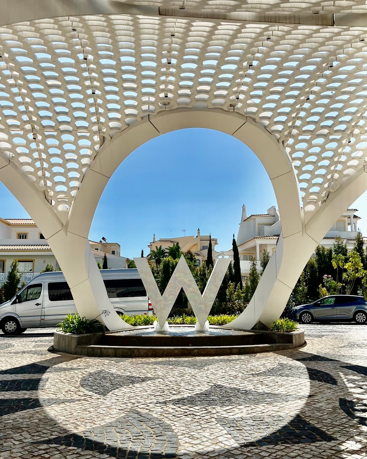 The entrance of the W hotel with a large white structure and a large white 'W' sign.