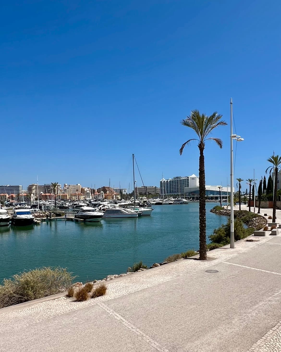 A view of the marina from Domes Lake Algarve hotel with boats docked and a path.
