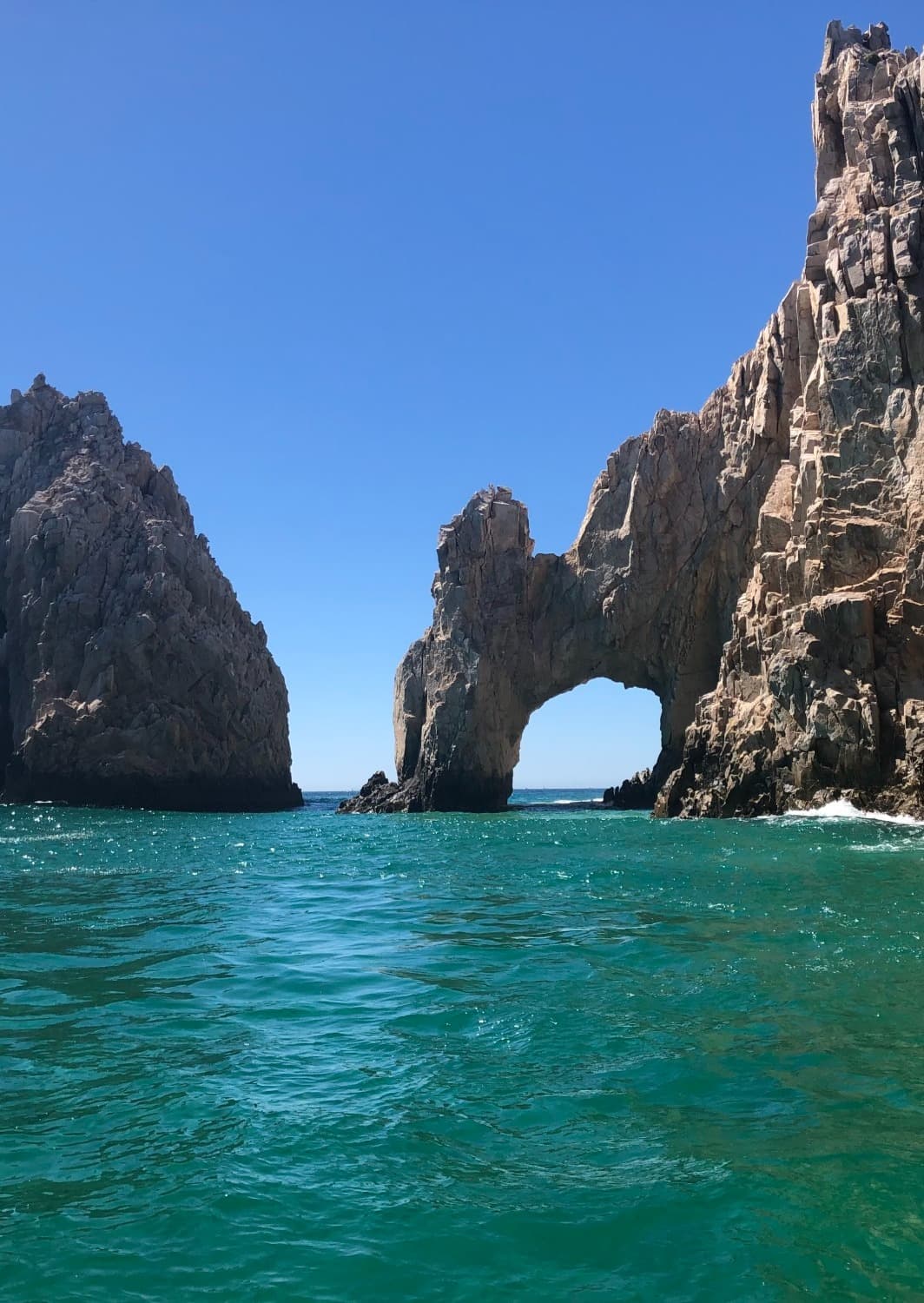 Large rock formations next to the cliffside in the water