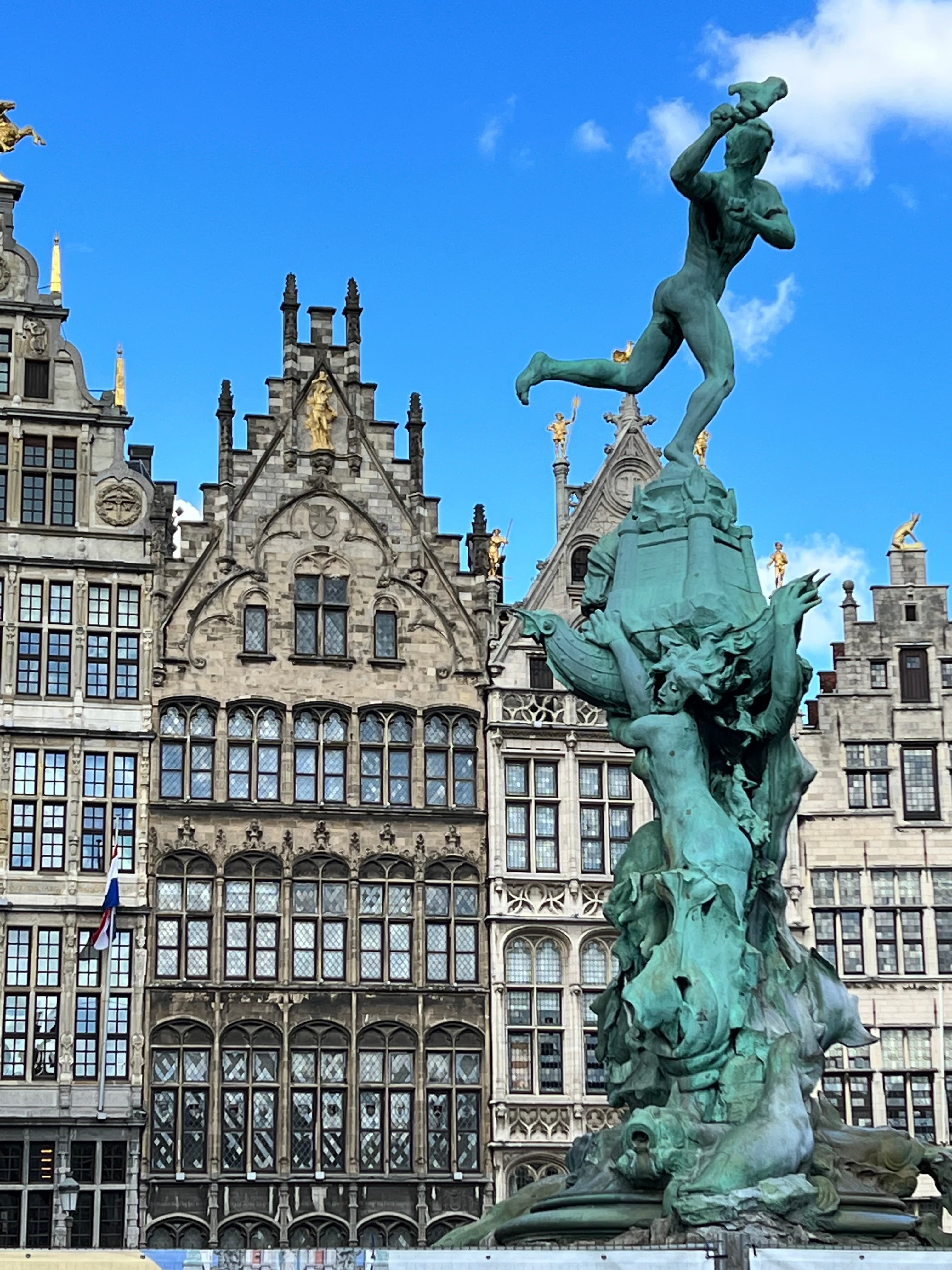 A blue statue in front of a row of tall, older buildings