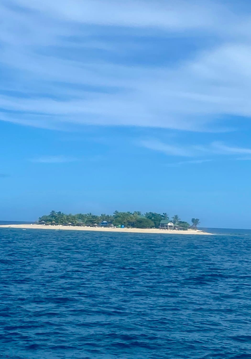 Blue ocean and blue sky with an island in the distance.