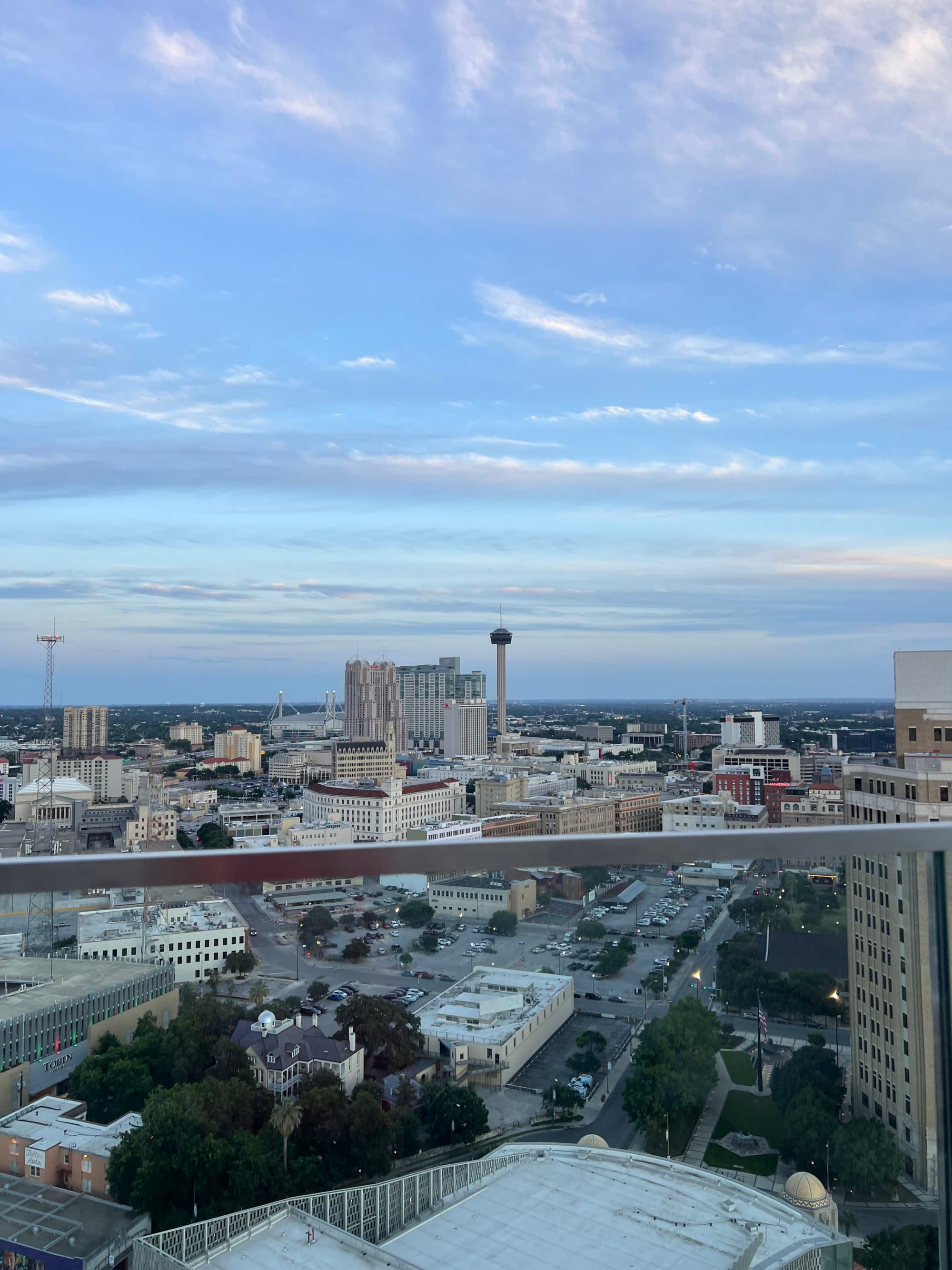 View of city buildings from a rooftop patio during the evening
