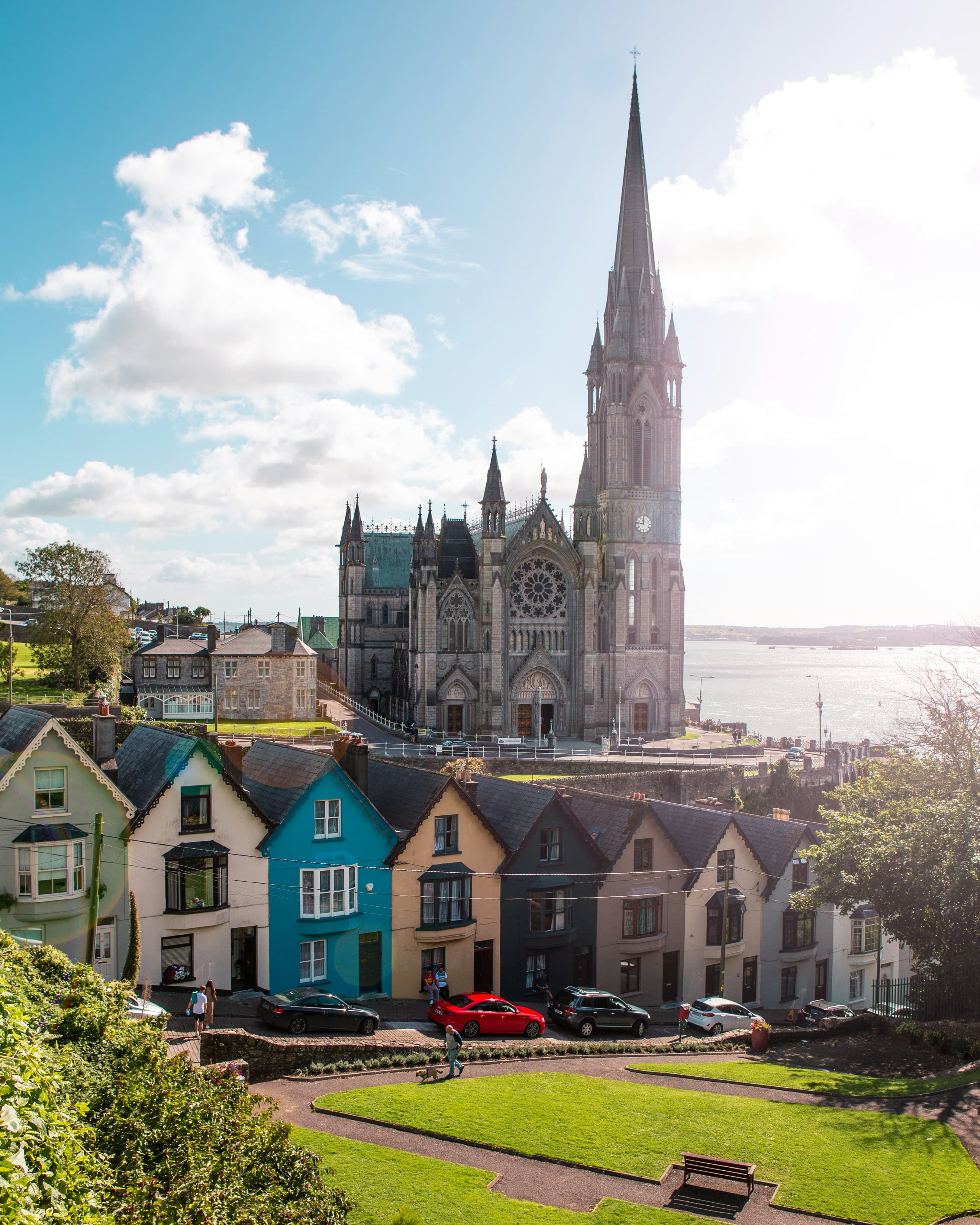 A cathedral and colorful houses in County Cork, Ireland, by the sea.