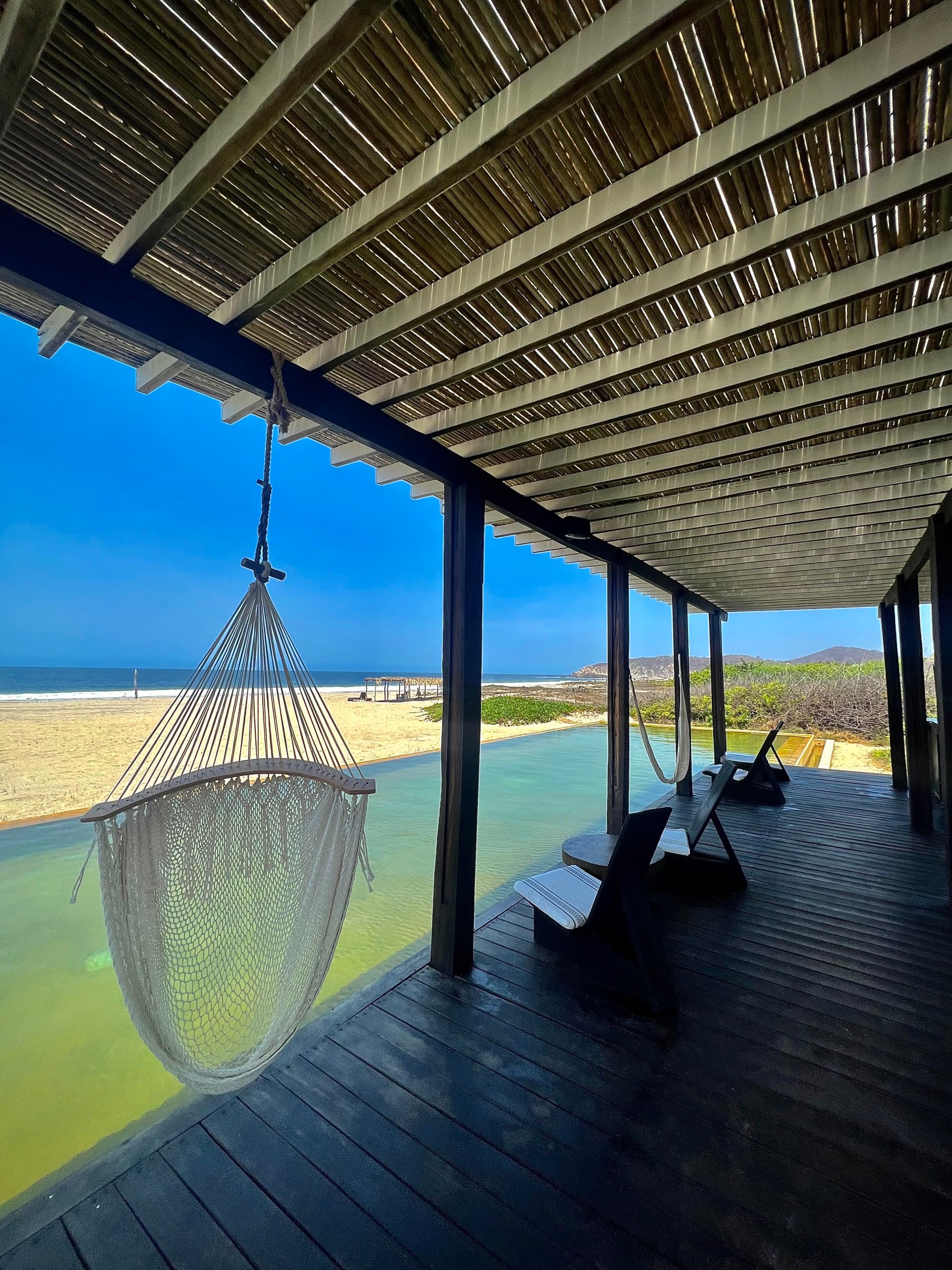 Sea and seaside view with a hammock in the foreground.