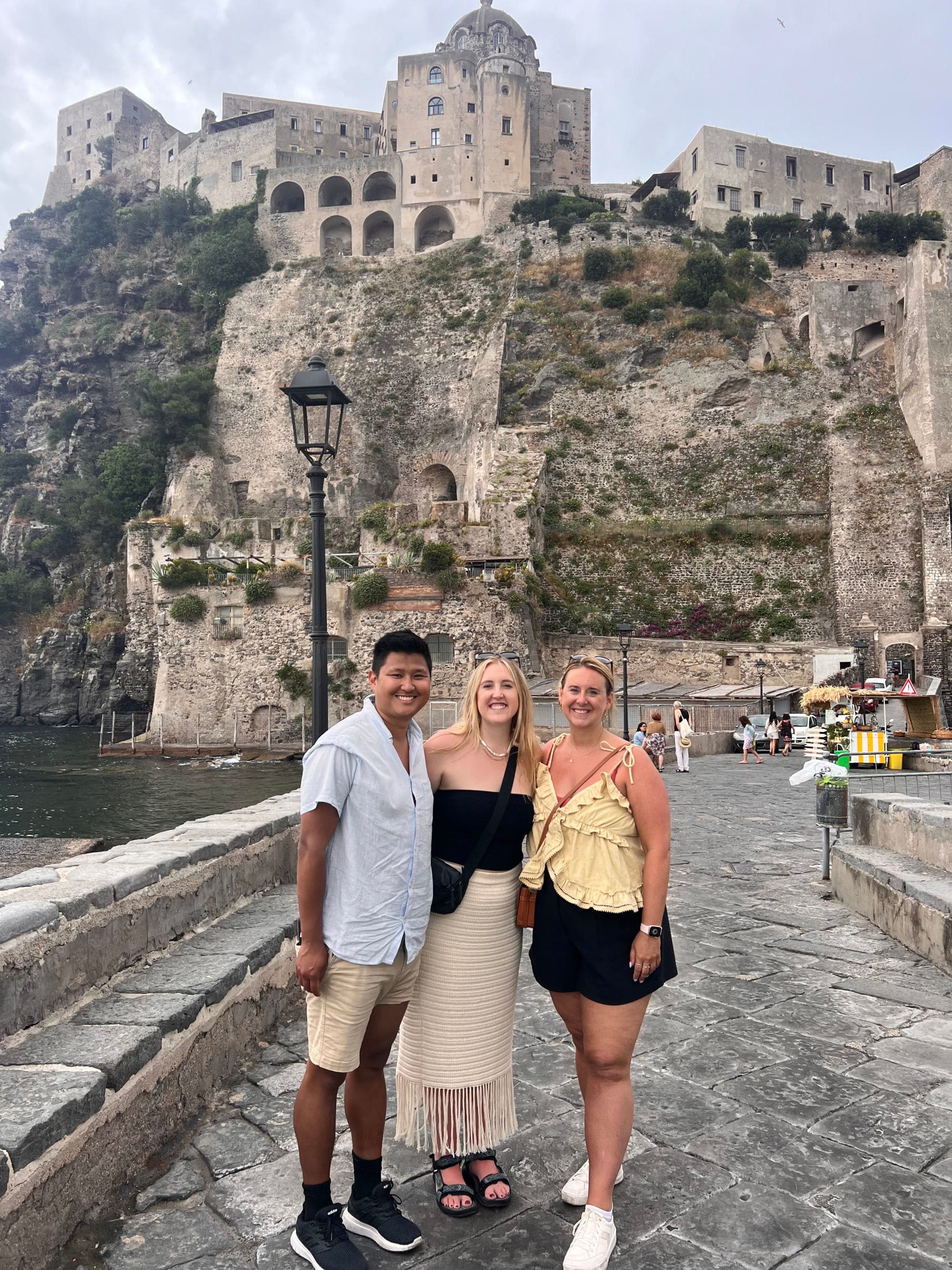 Travel advisor posing with a mountain scape in the distance on a sunny day with friends.