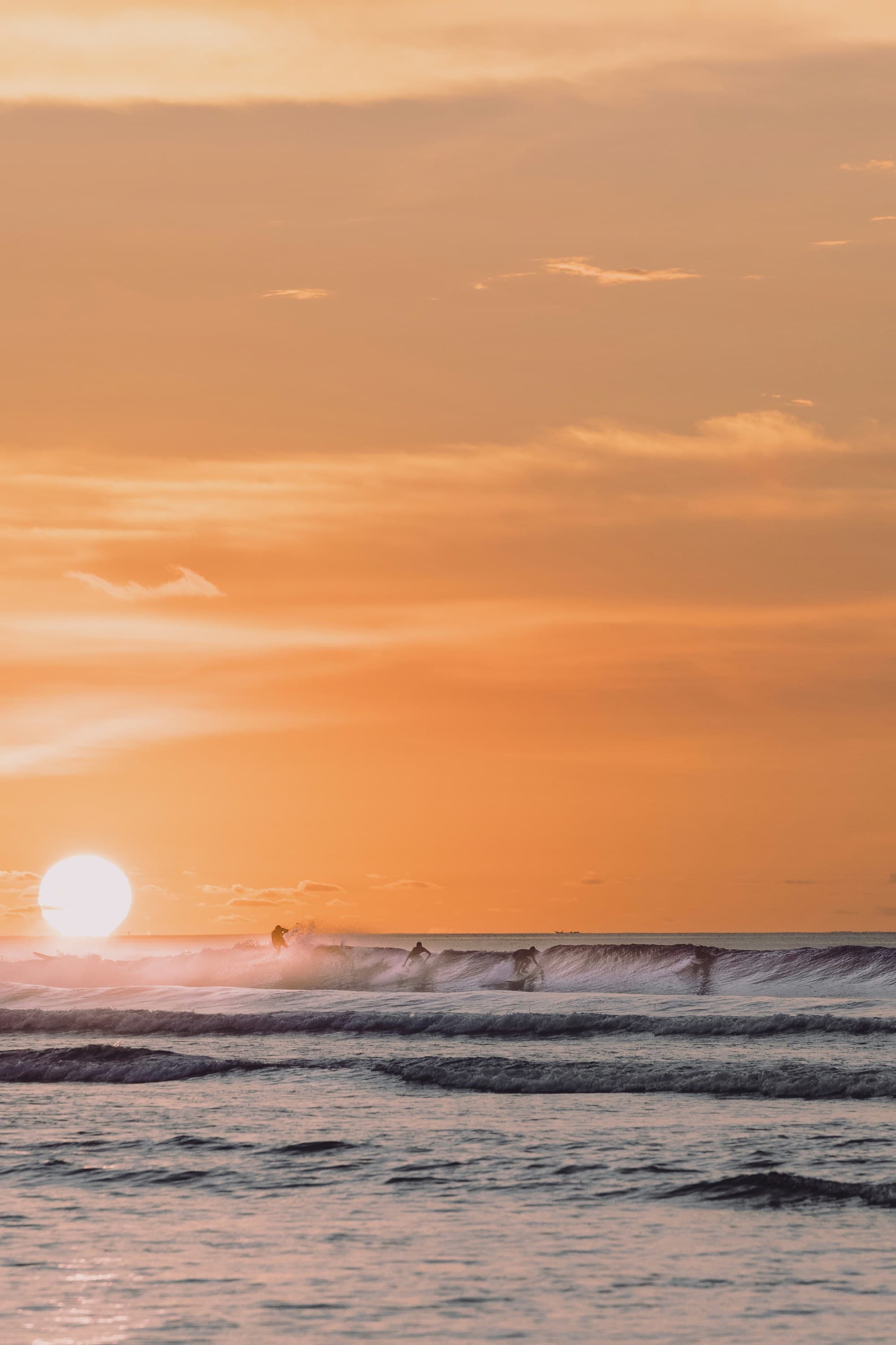 Ocean waves crashing on shore during sunset.