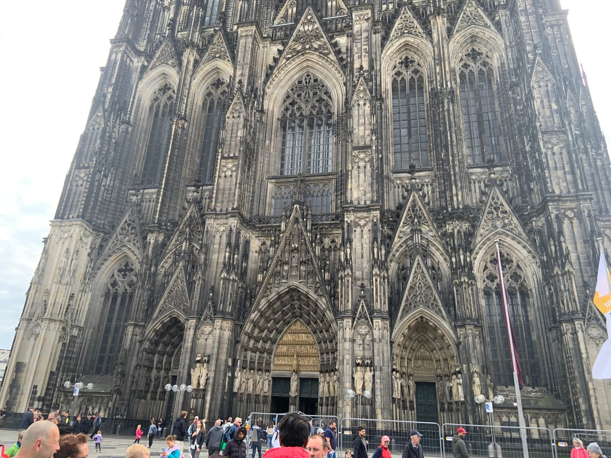 Cologne Cathedral in the day time with a crowd of people surrounding the building.