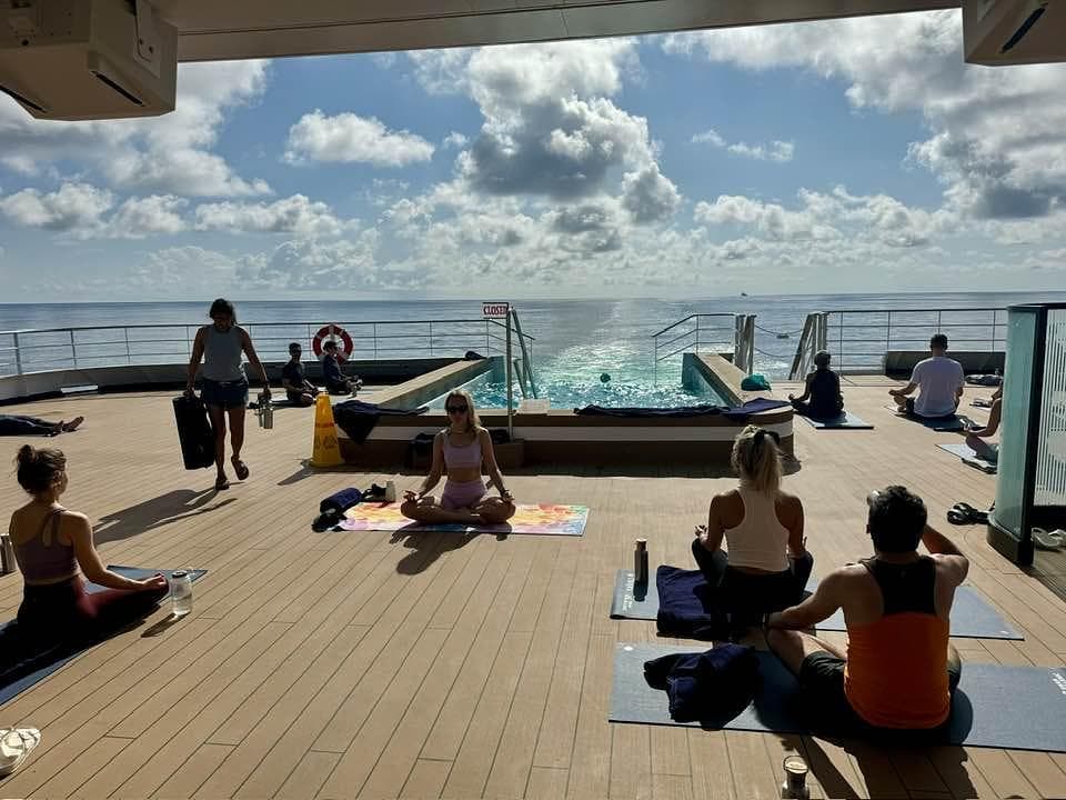 A group of people doing yoga on the deck of a cruise ship.