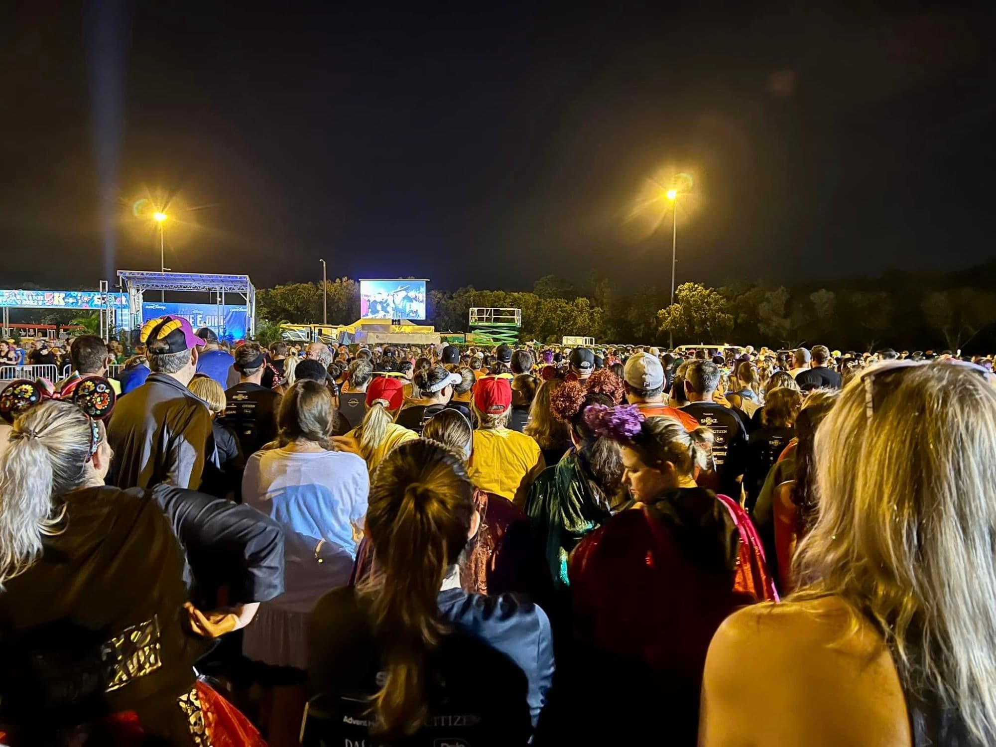 A crowd of people standing outside at nighttime