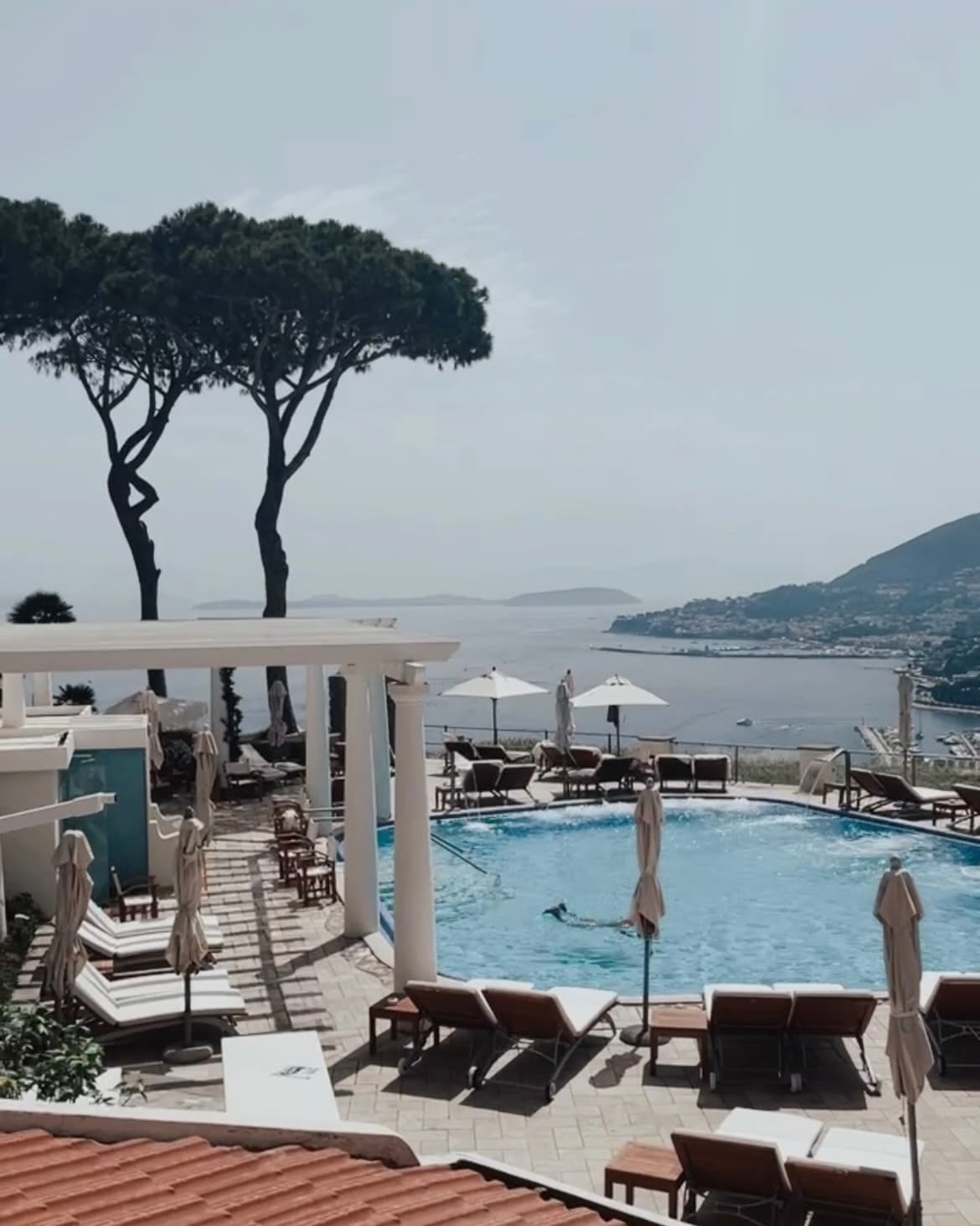 Poolside at the resort, with a view of the Mediterranean Sea and landscape.