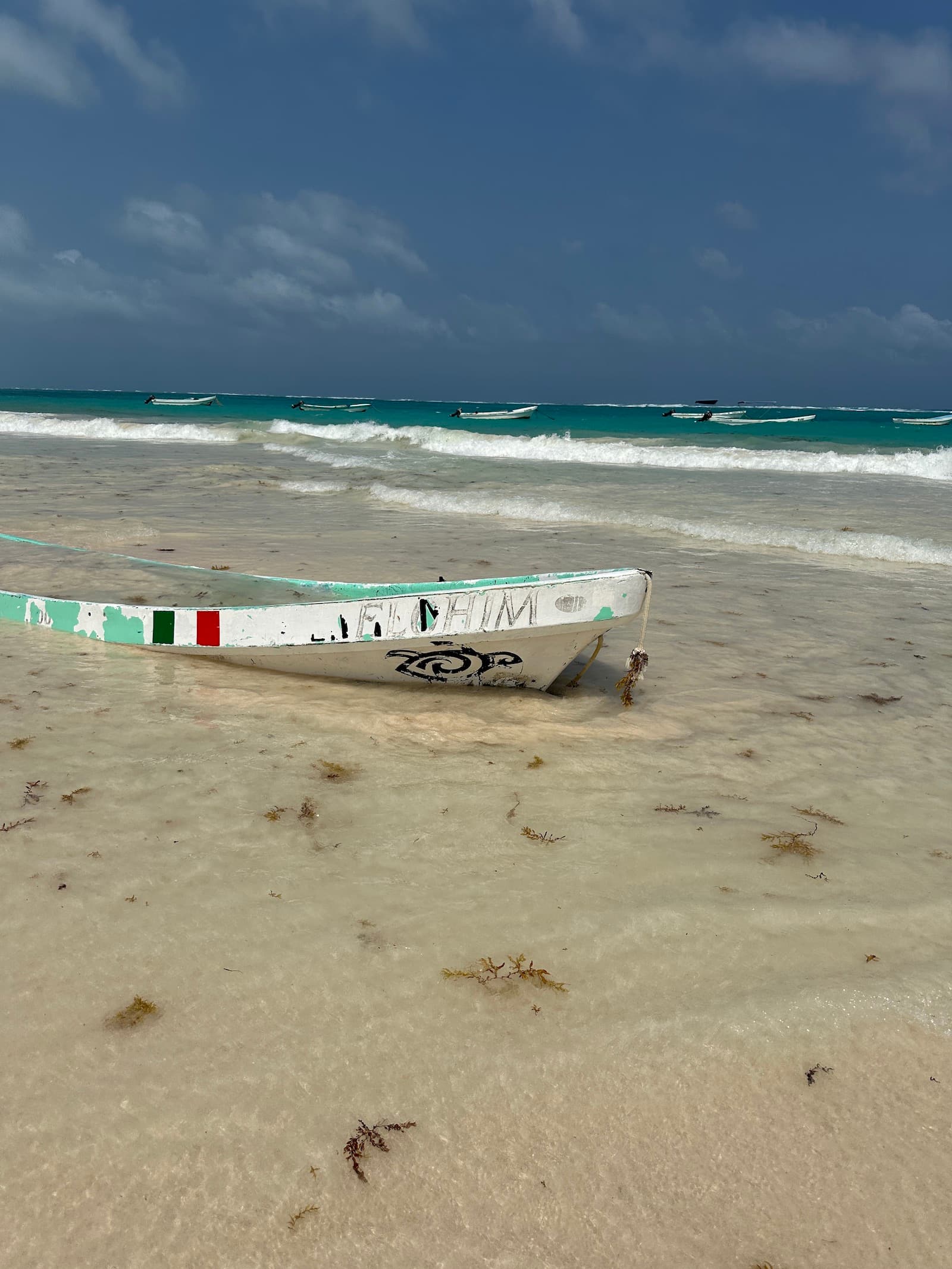 A boat half-buried in the sand on the beach during the daytime