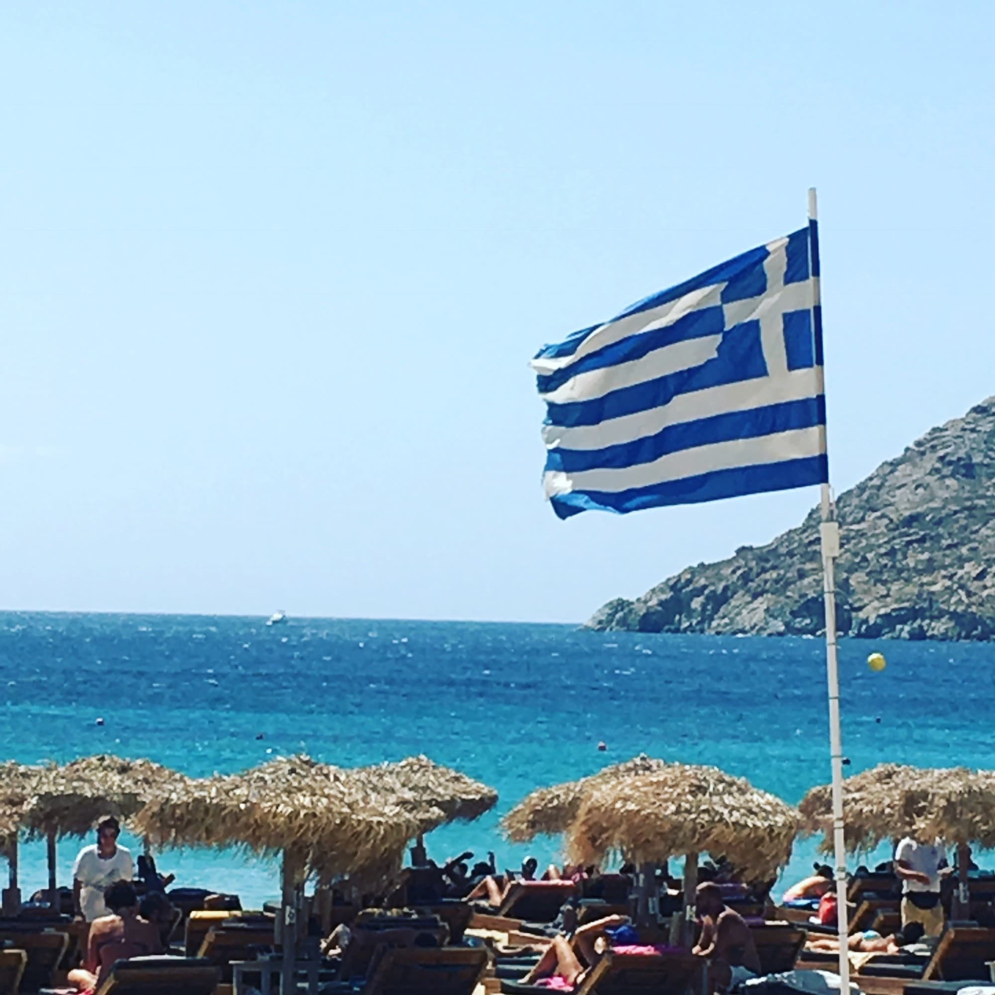 A view of the ocean with the Greek flag flying in the wind