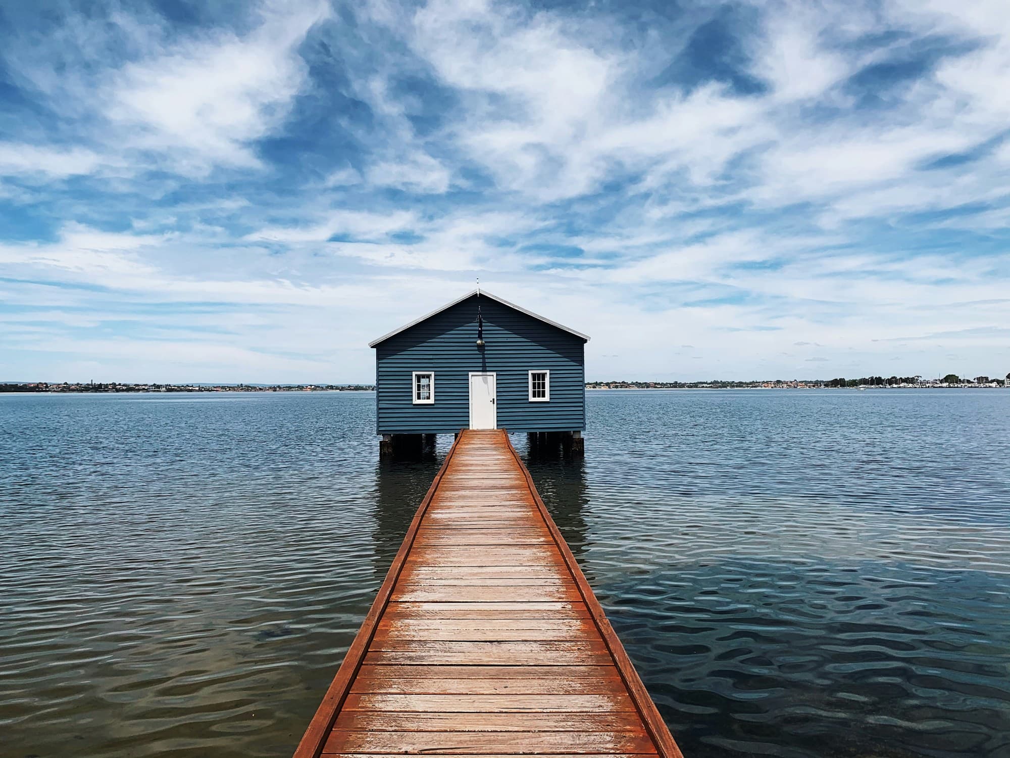 Brown wooden dock on the sea under blue sky during the daytime