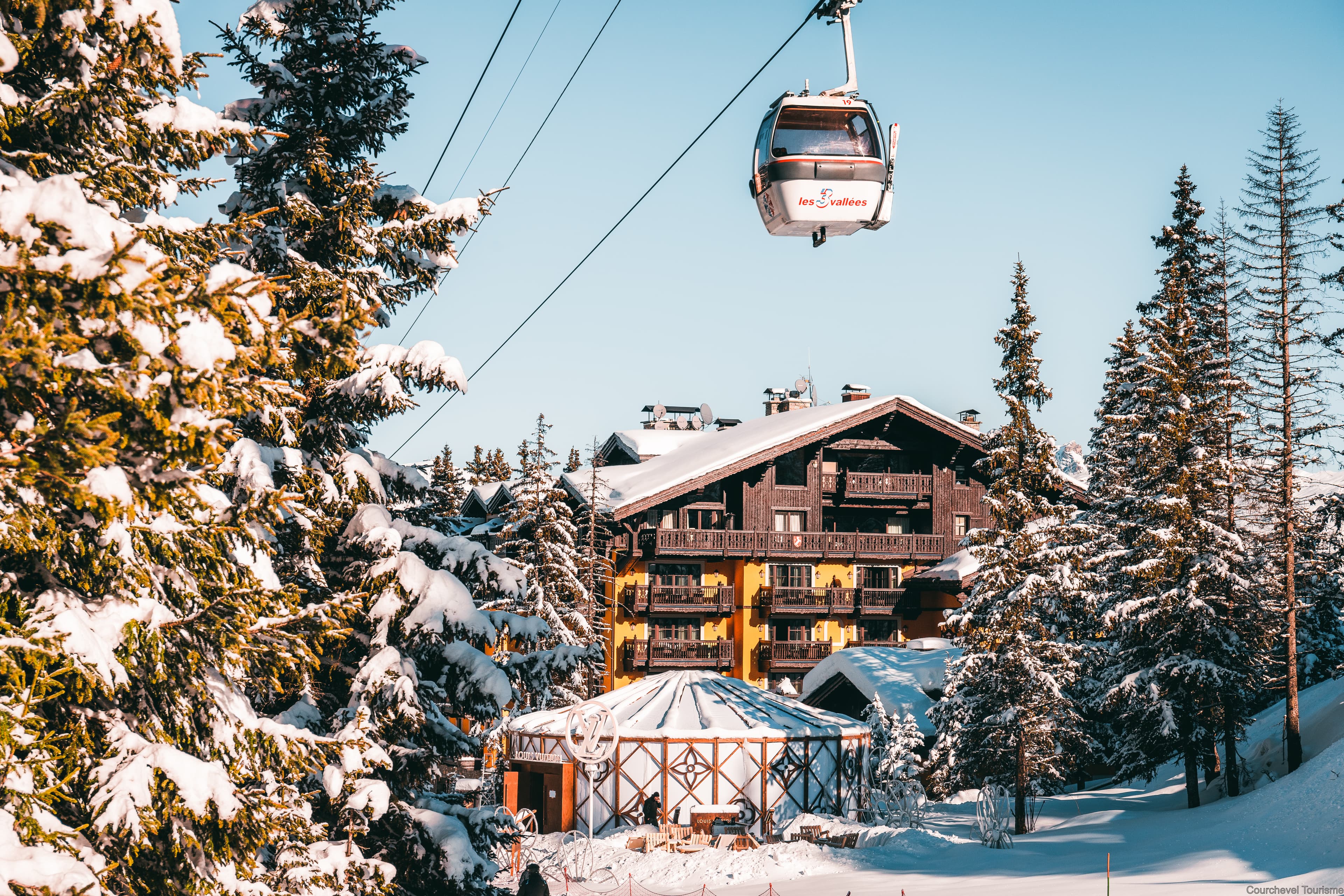 View of Courchevel France ski resort from above with chalets and trees.