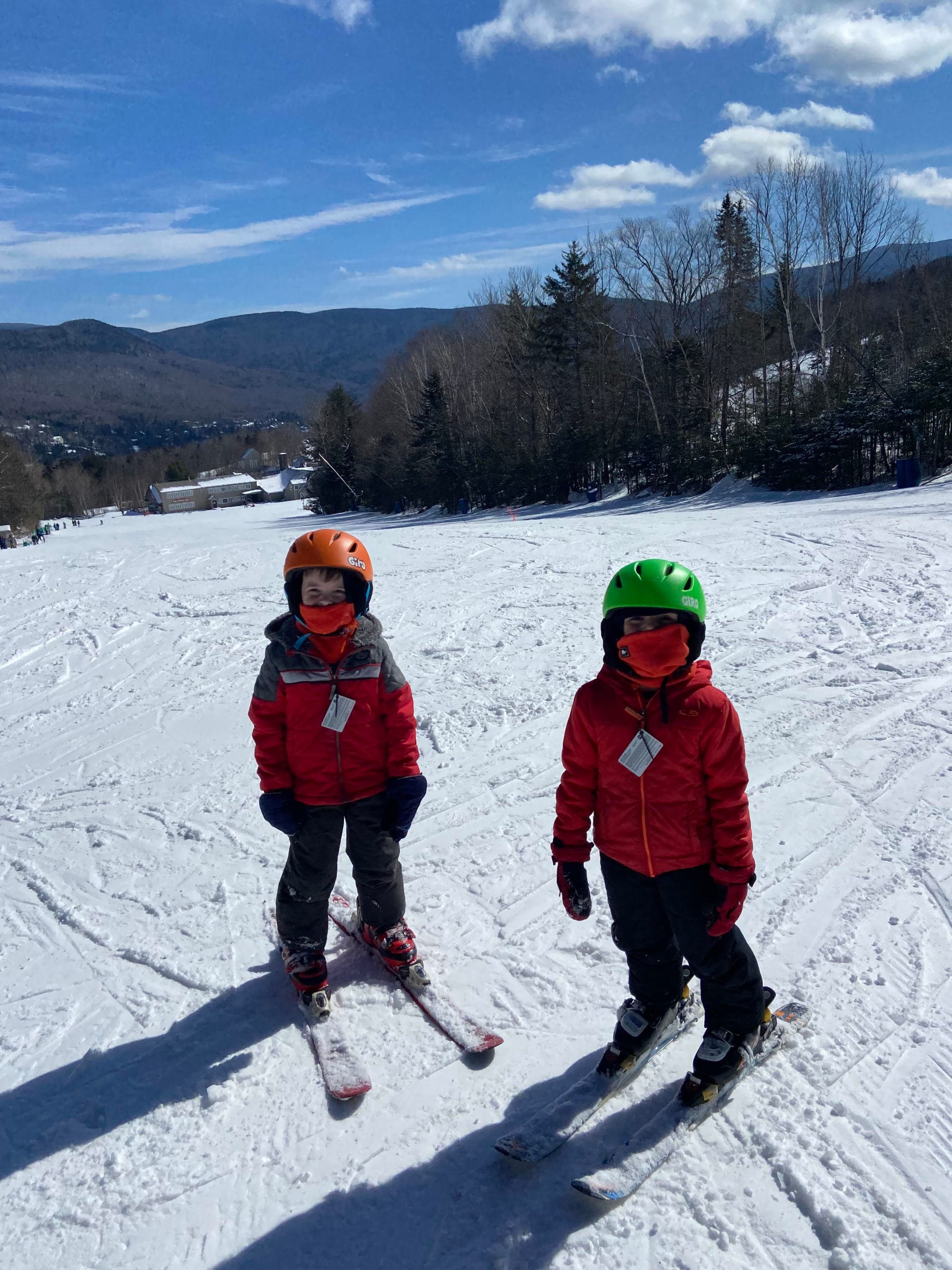 Fora Advisor Angela Poulin's twins skiing at Waterville Valley - two children in red coats on a snow-covered mountain with buildings in the background