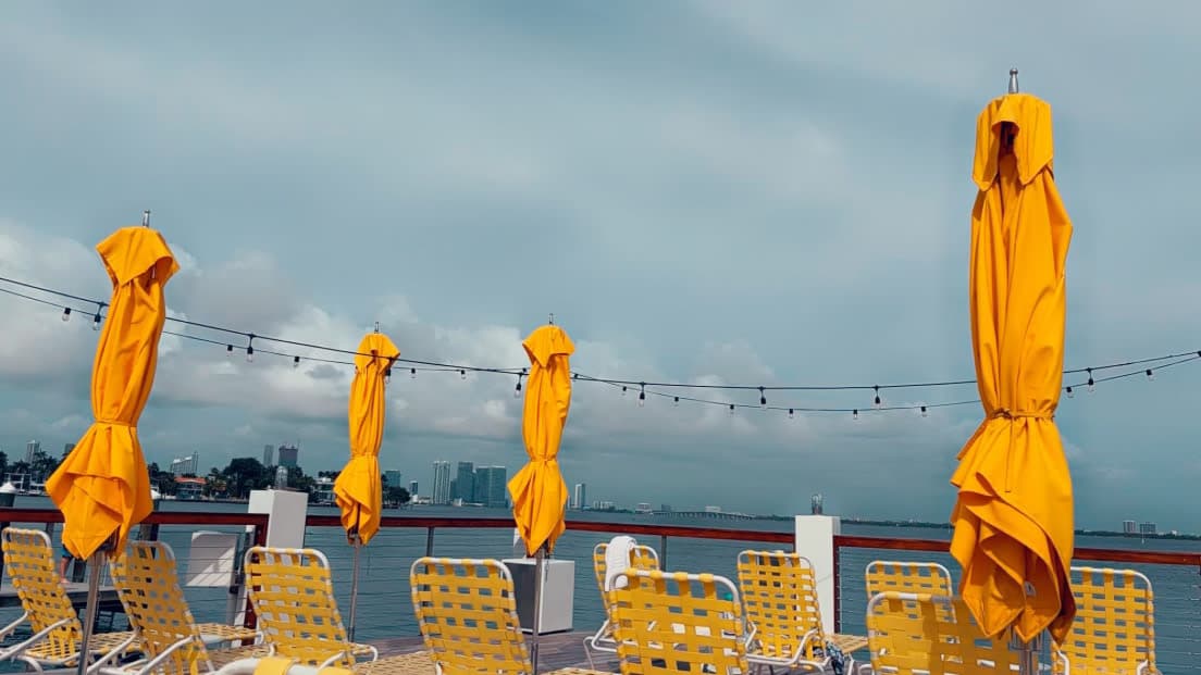 Seaside view with an outdoor seating area and umbrellas.