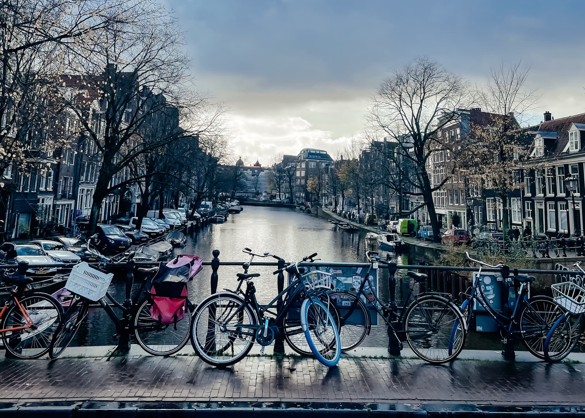 Canal and canal side view with bicycles and a beautiful view of Amsterdam architecture.