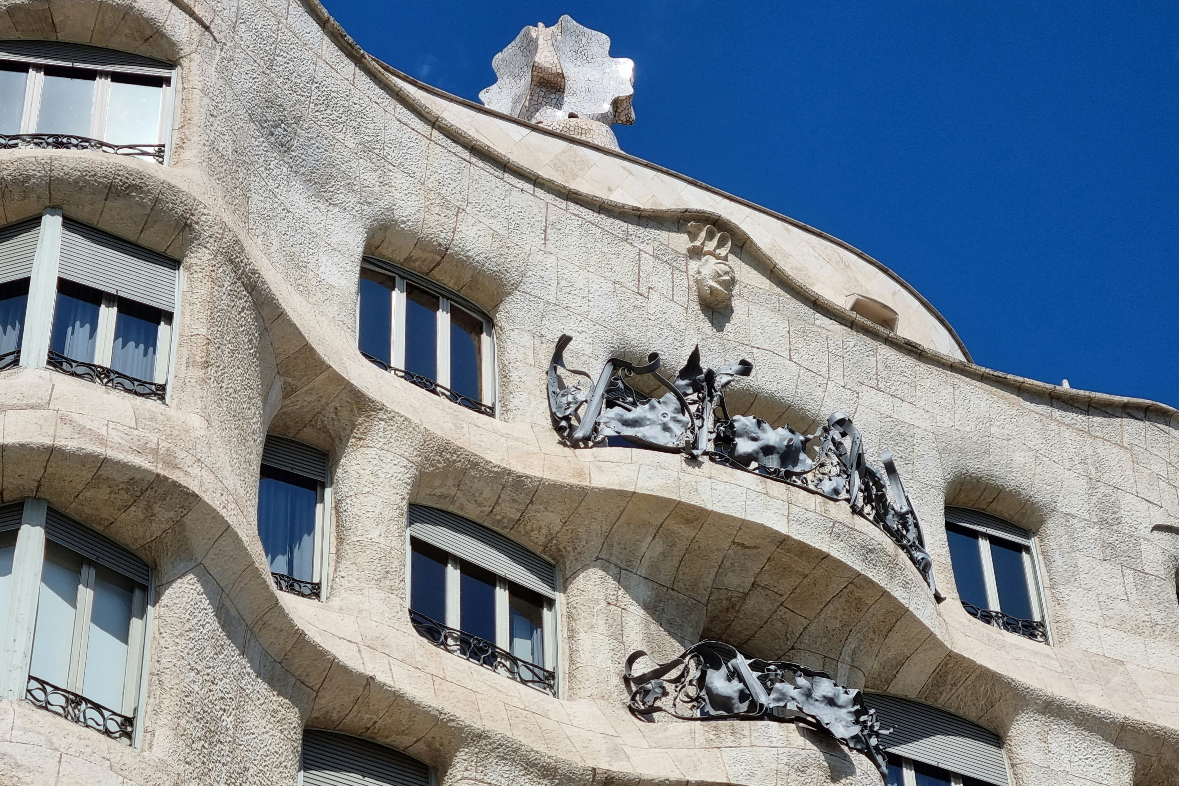 a curvy, modernist stone building against a blue sky