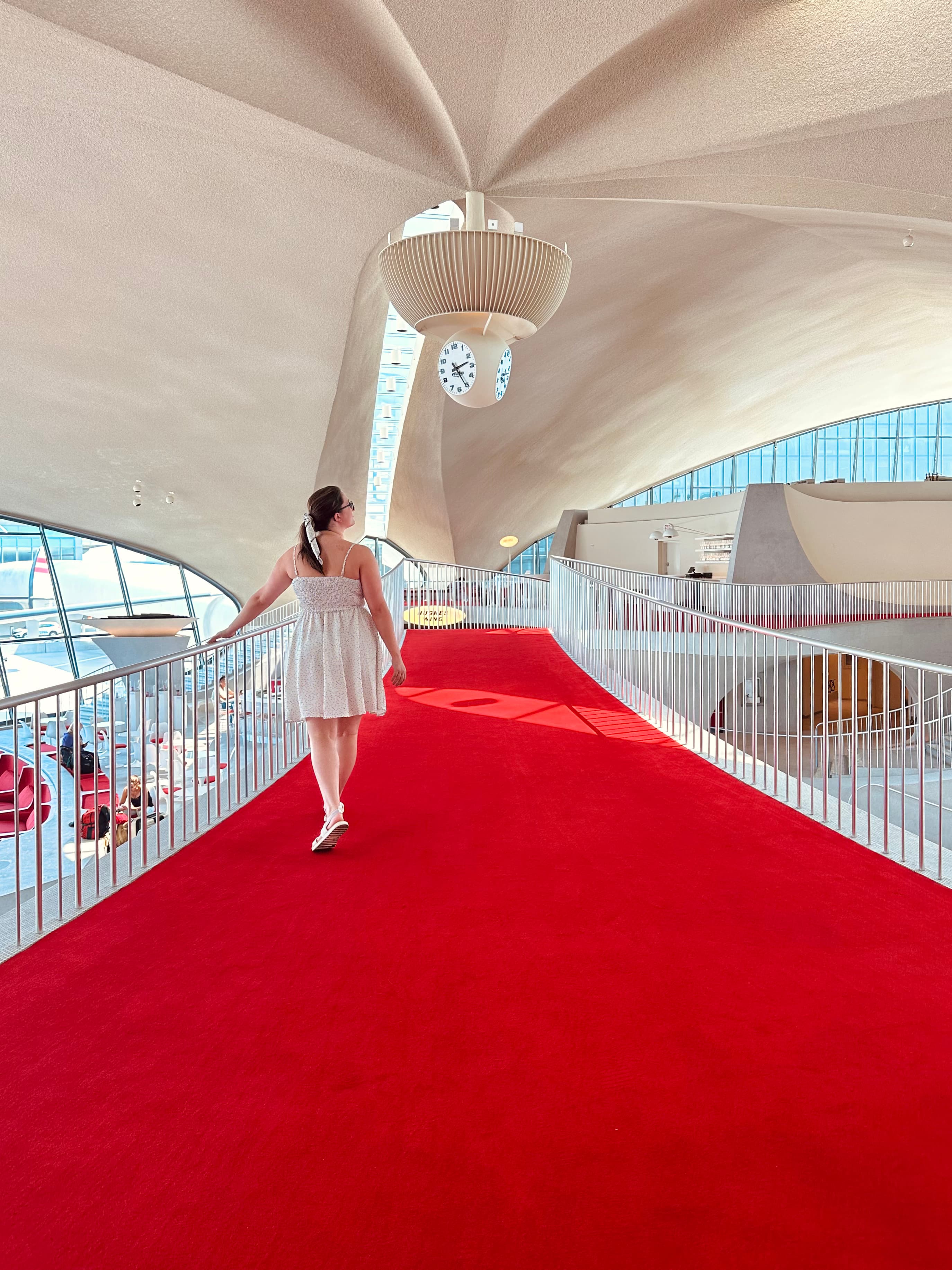 Travel advisor Tessa walking on a red walkway at TWA Hotel