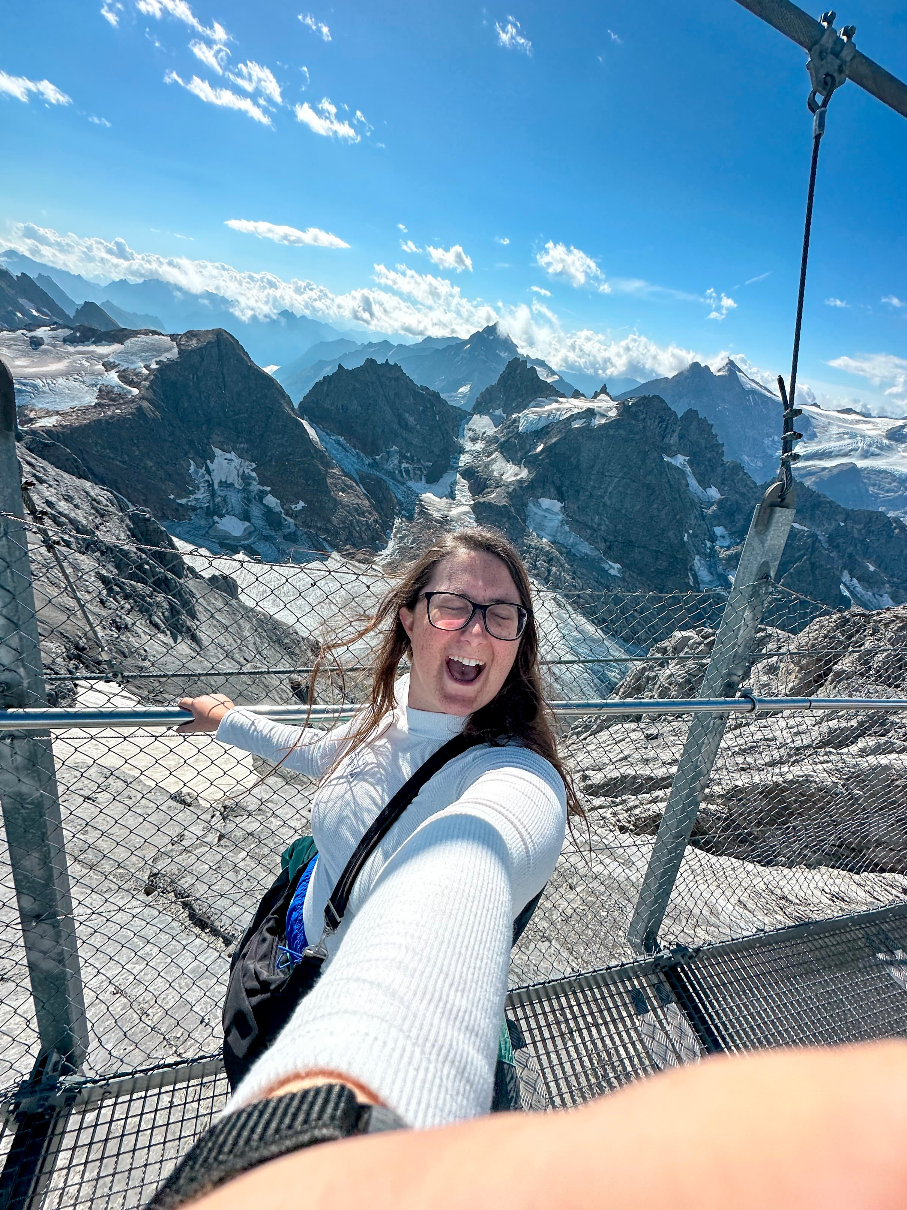 Travel advisor Tessa posing on a wire walkway on Titlis Cliff Walk with beautiful view of cliffs