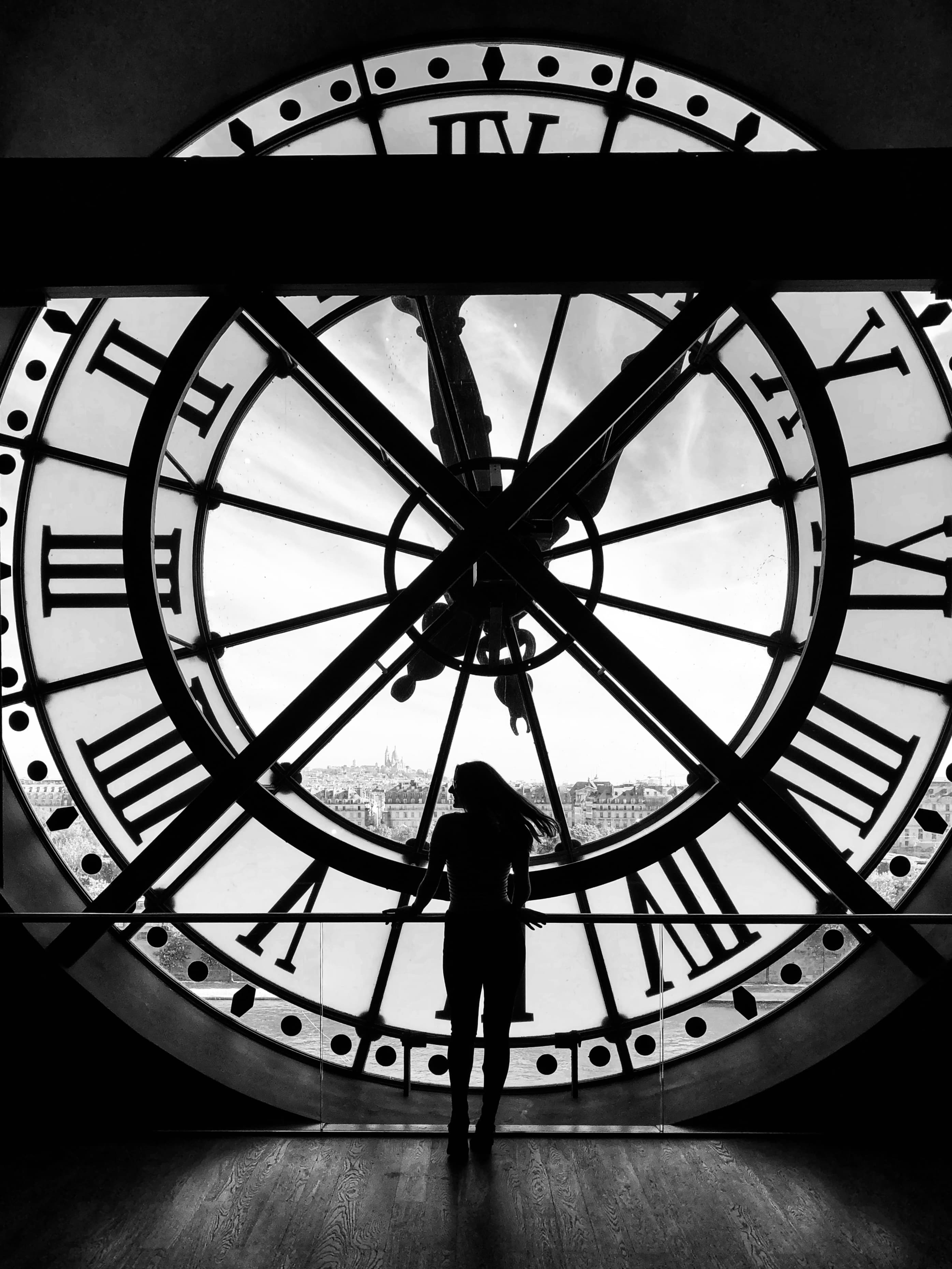 Black and white view of a large clock with Roman numbers at Musée d'Orsay Art museum