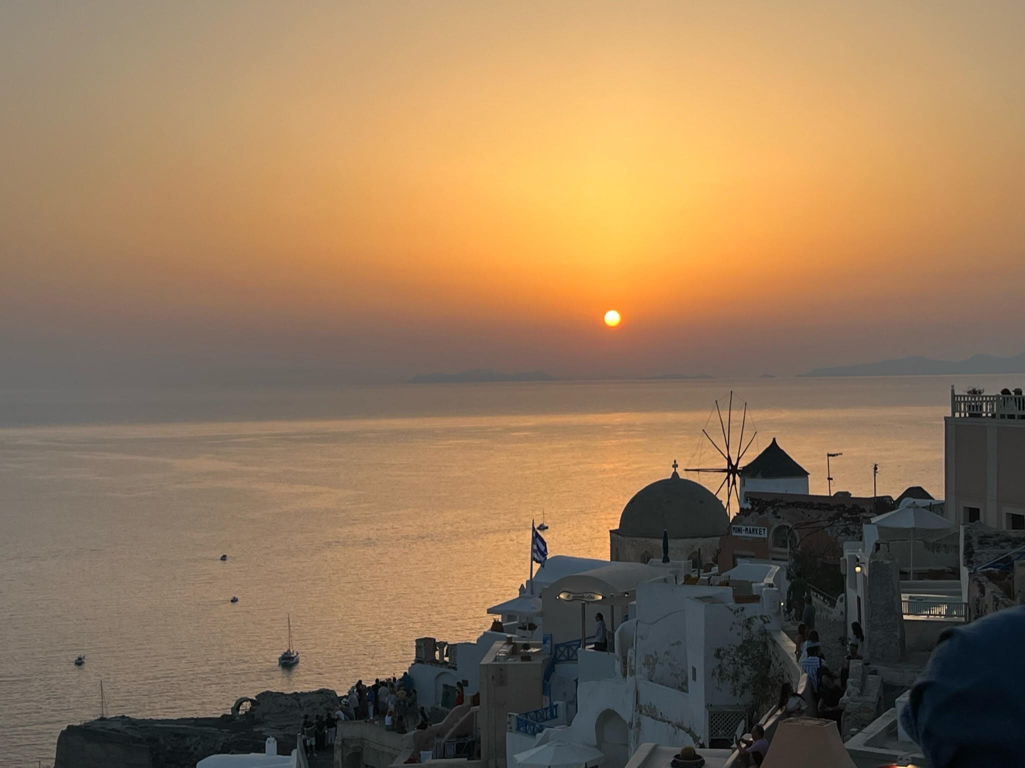 Beautiful view of ocean and buildings on the caldera at sunset in Santorini