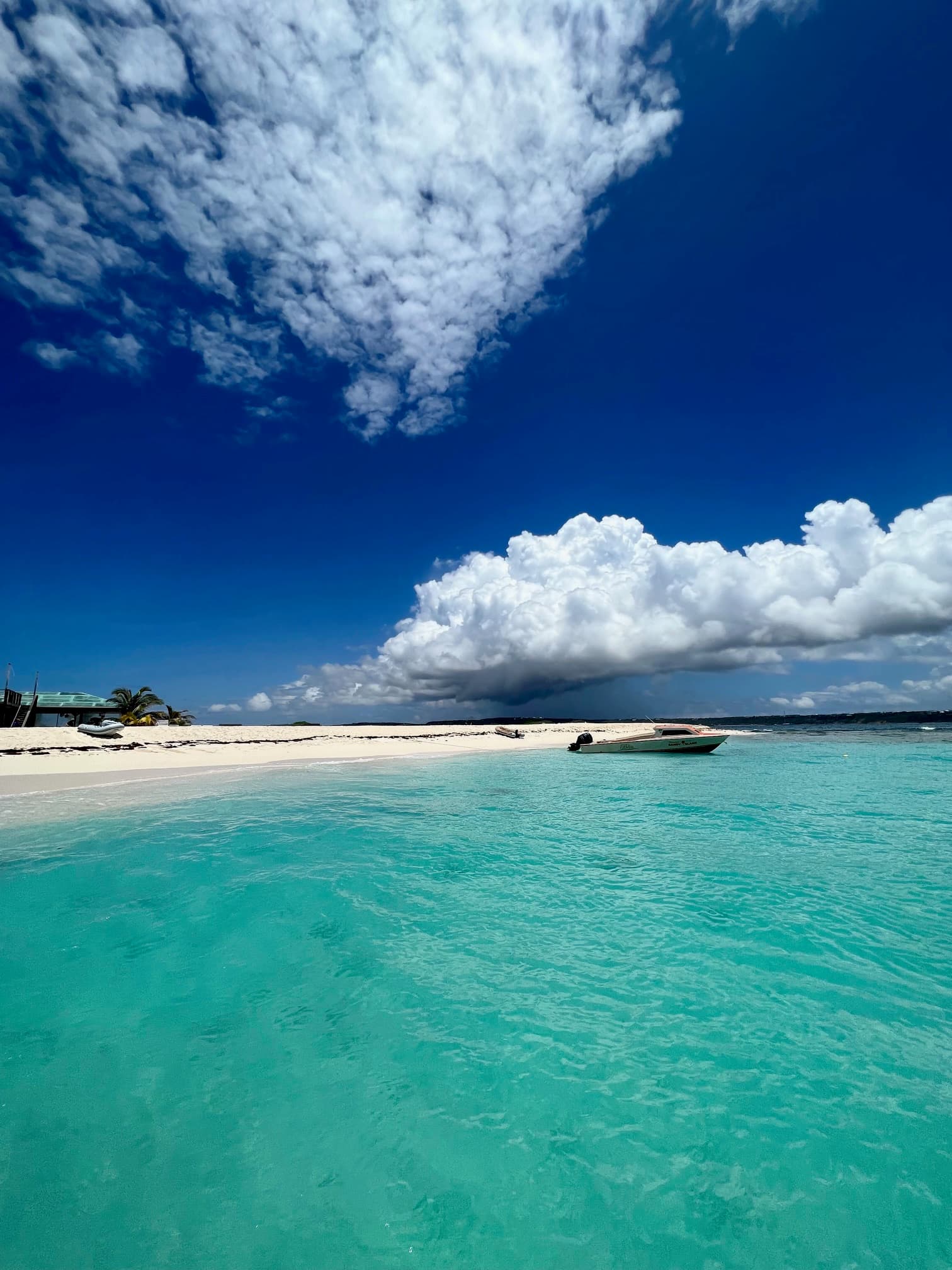 Beautiful view of a beach with turquoise ocean and white sand on a sunny day with some clouds