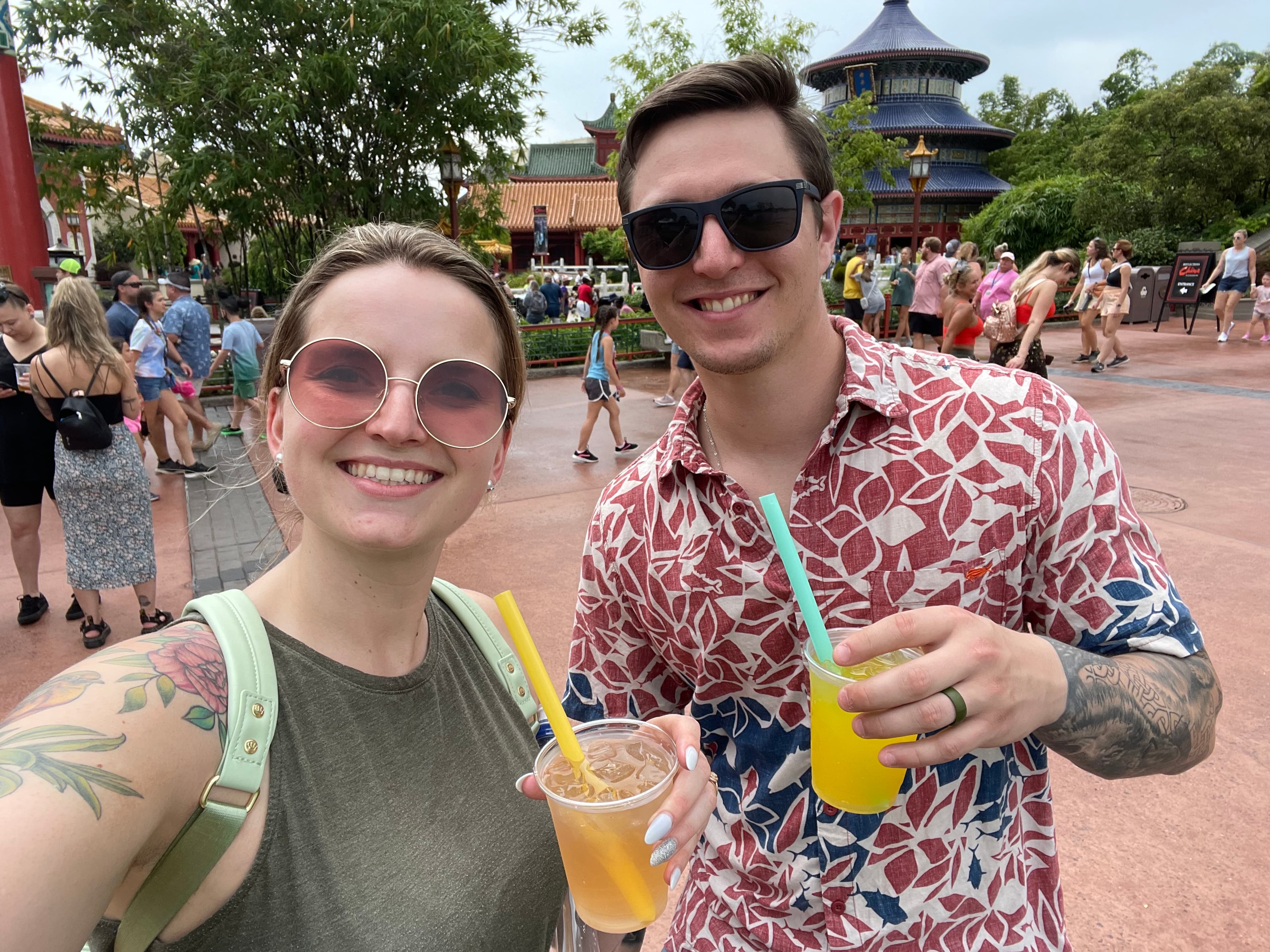 Travel advisor Elizabeth posing with a male companion drinking orange-colored drinks