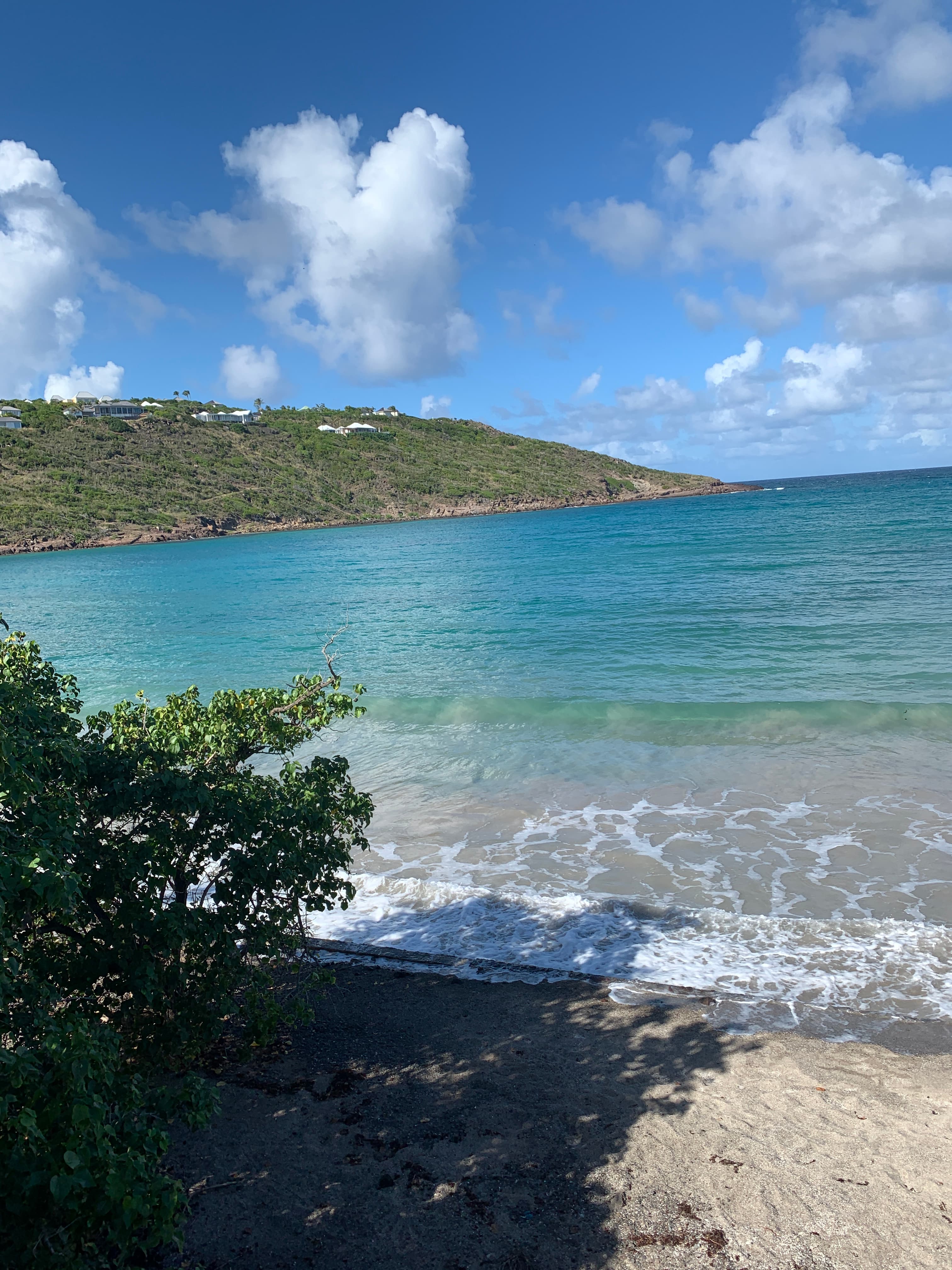 St. Barths beach with green hills in the distance.