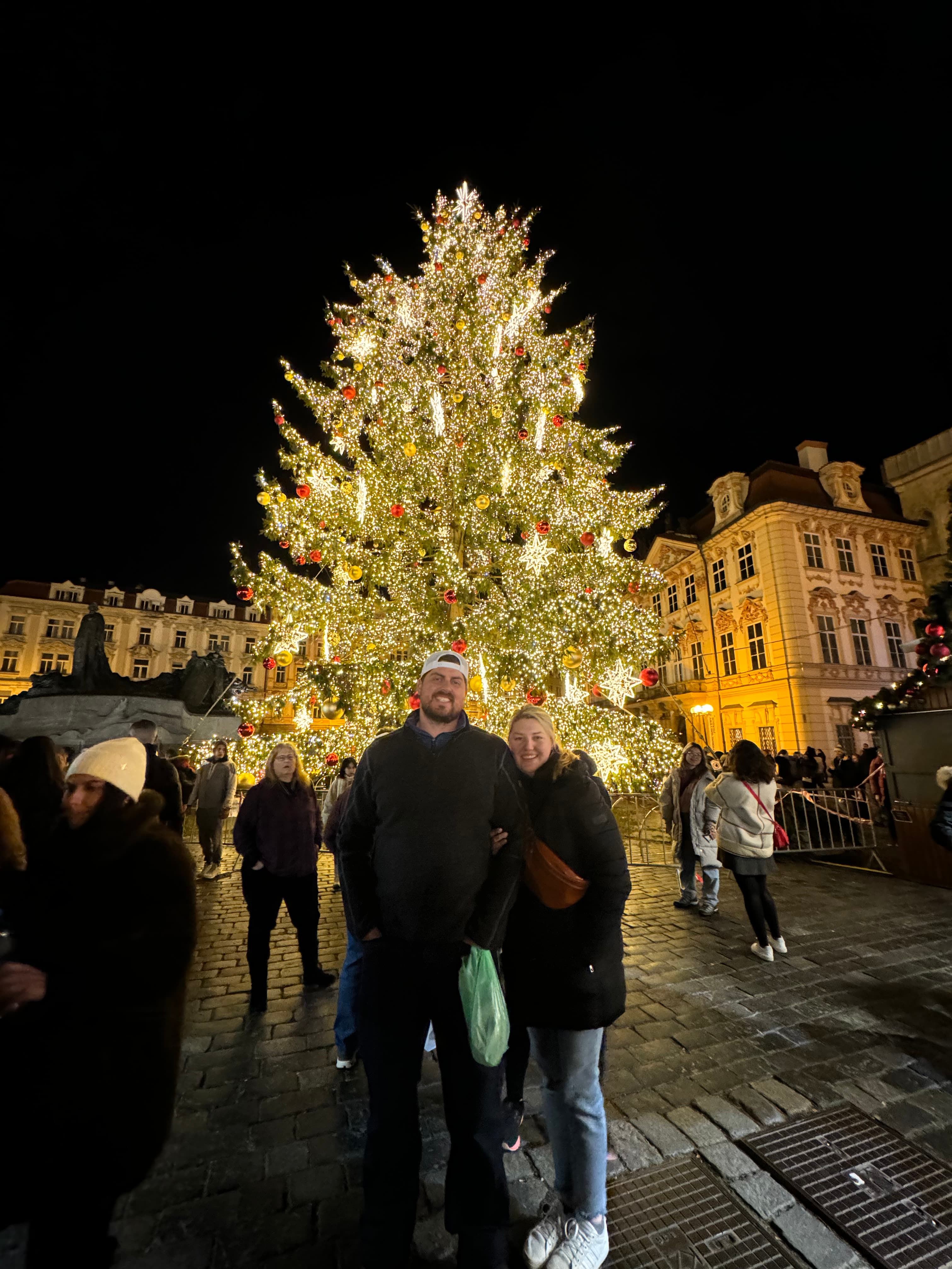 Posing for a photo in front of a Christmas tree