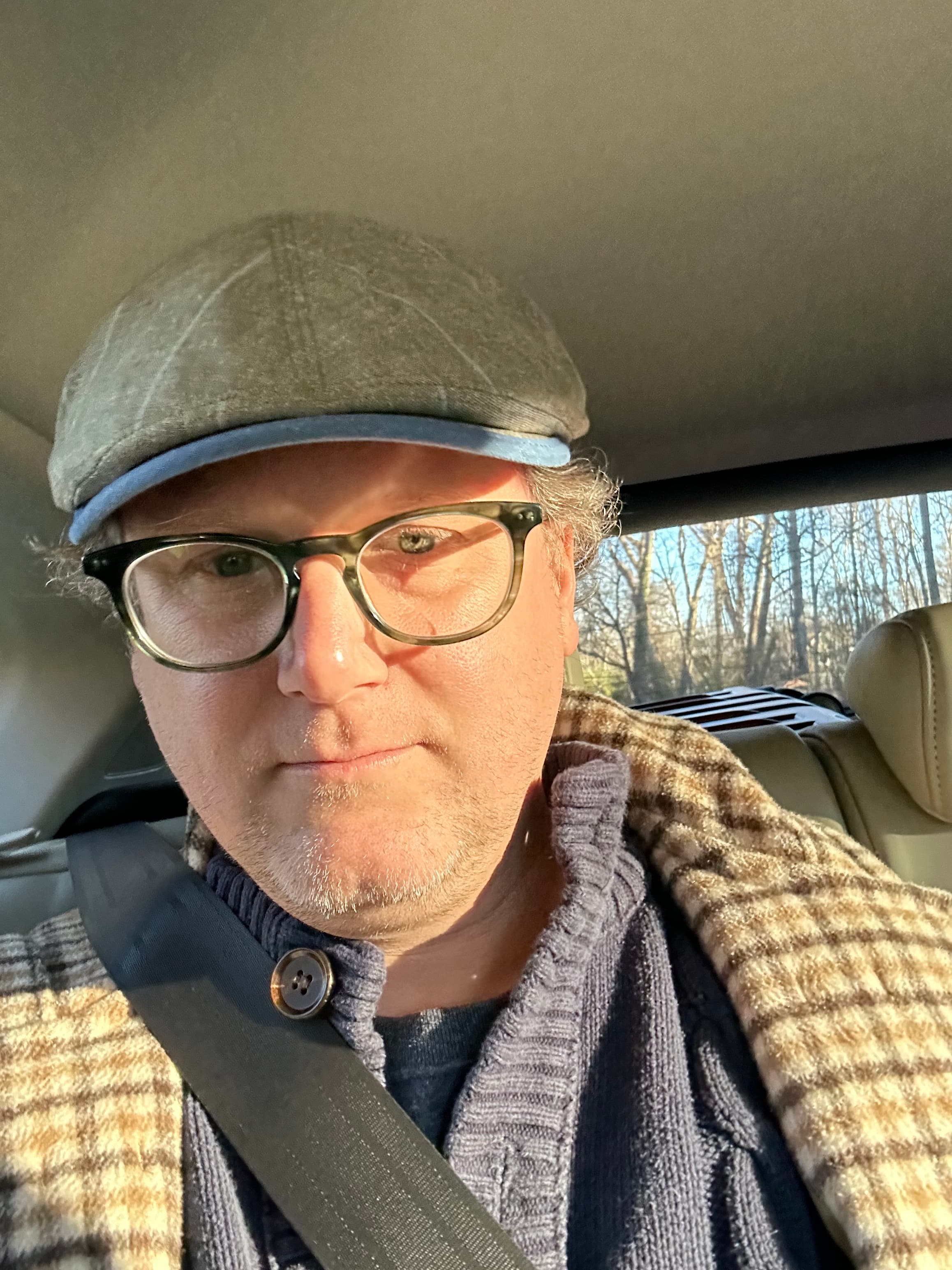 Travel advisor Joshua in a hat inside a car