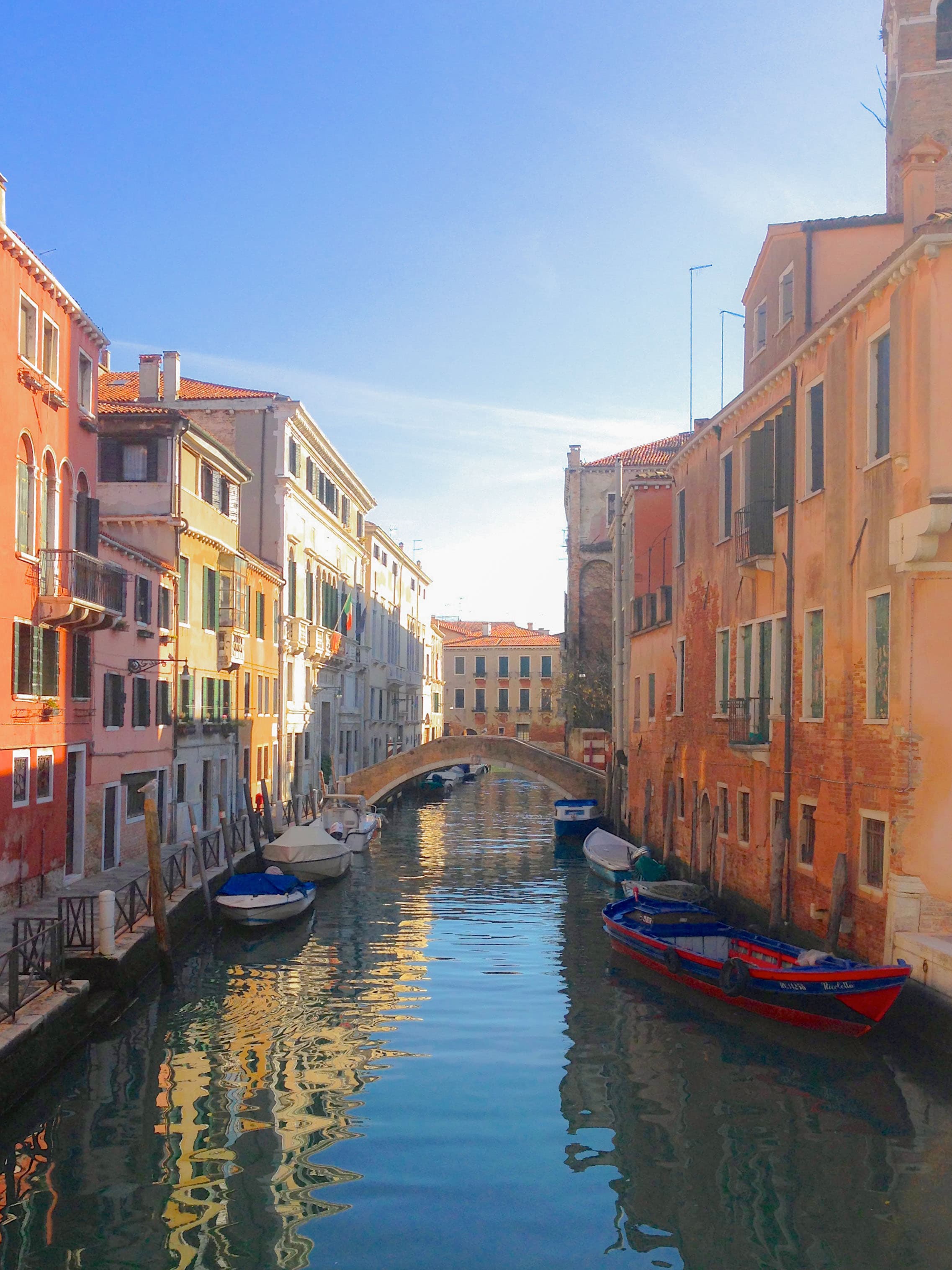 View of a canal in Venice with boats and colorful buildings either side