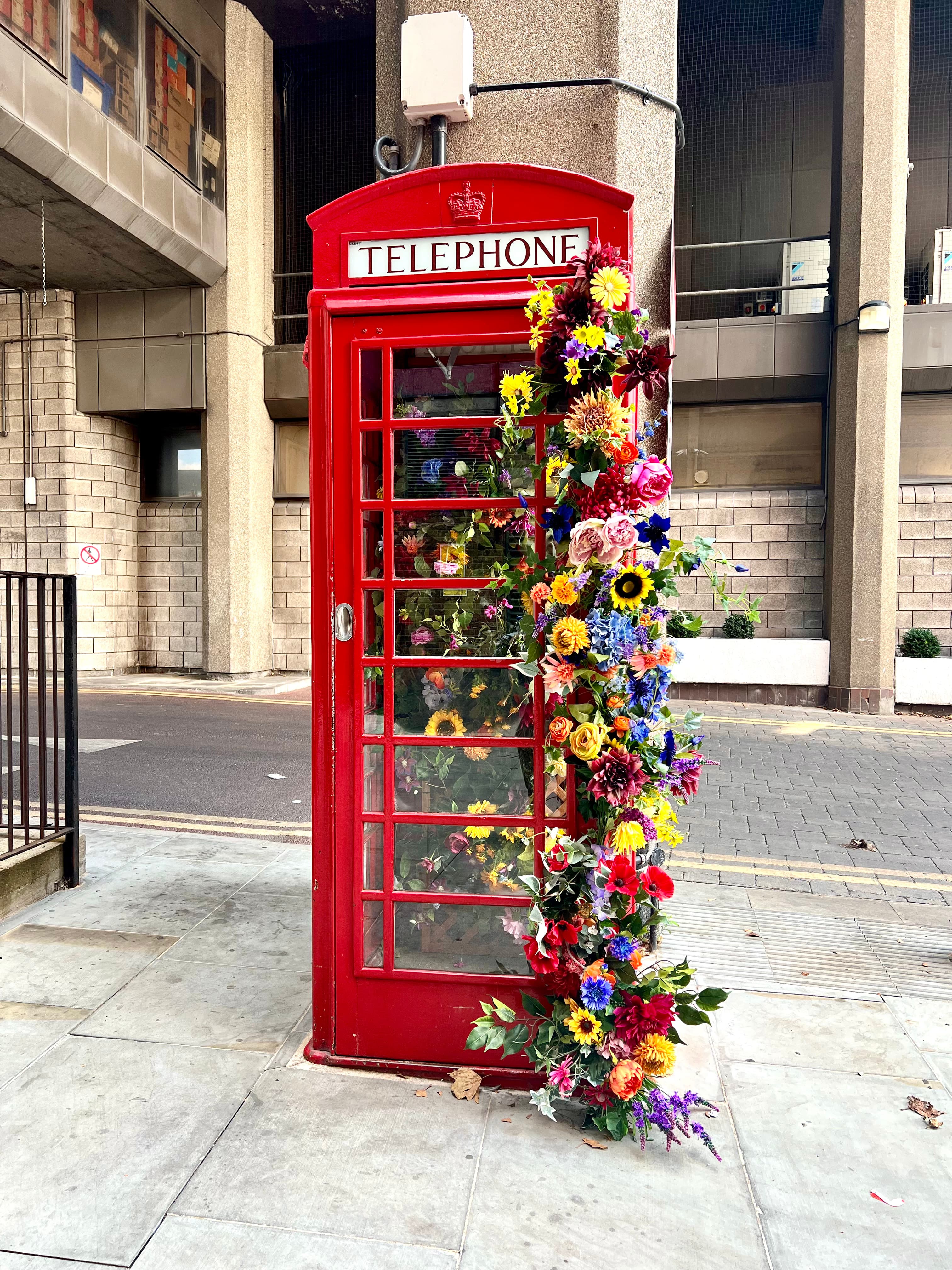 Photo of a red London phone booth decorated with flowers