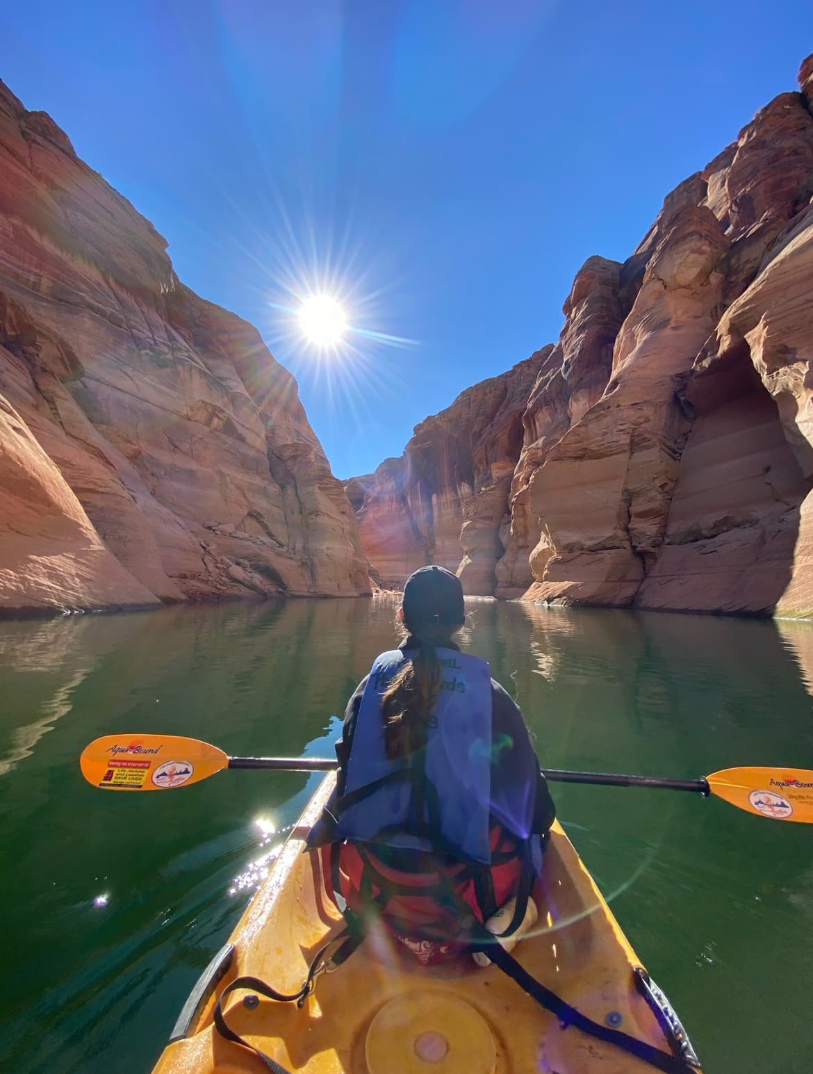 Travel advisor Kayla rowing on a lake between pink-colored mountains