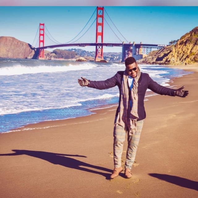Travel advisor Samuel posing on the beach with the Golden Gate Bridge in the background