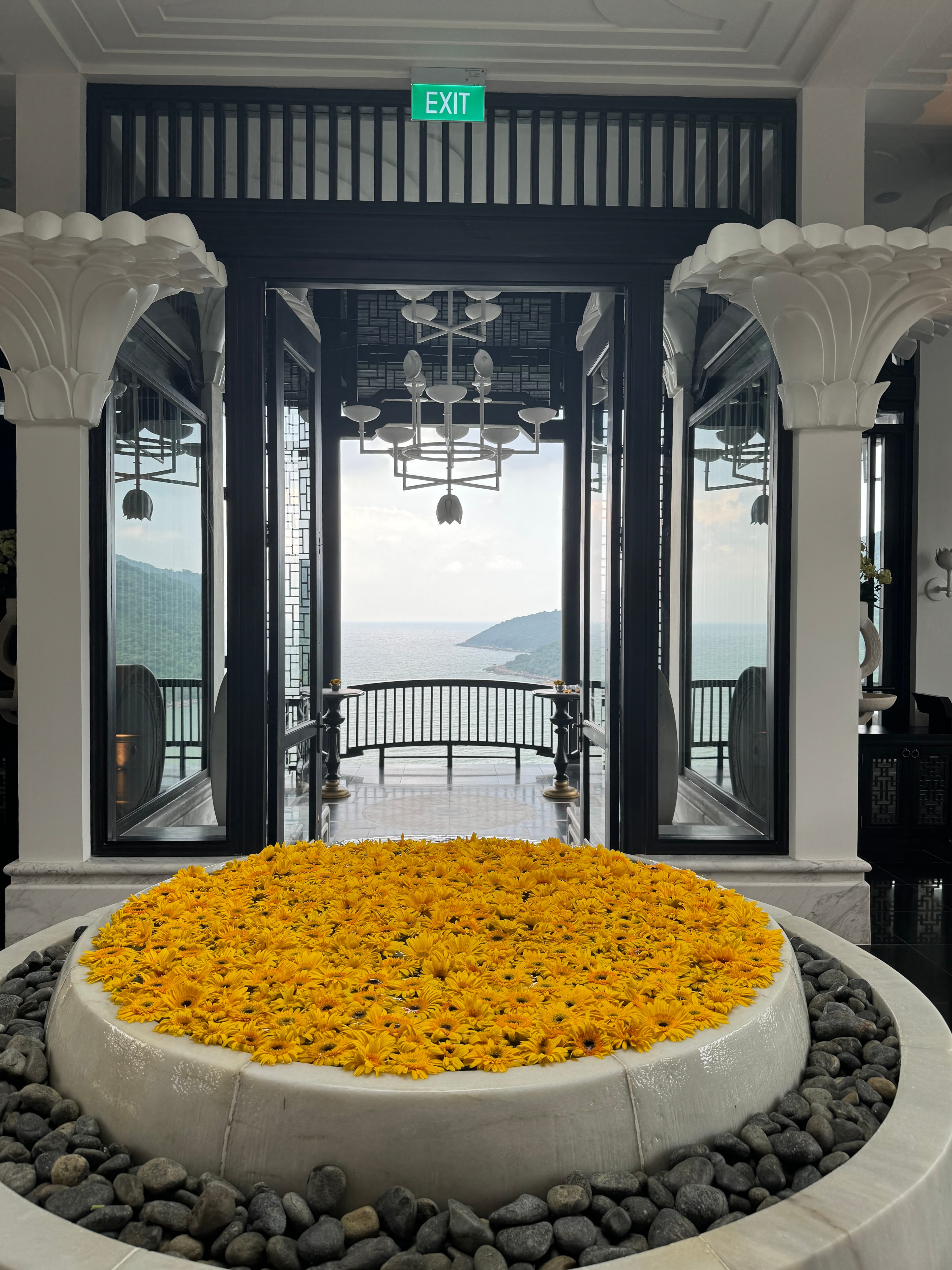 Beautiful decor with circular structure filled with sunflowers in between two white pillars
