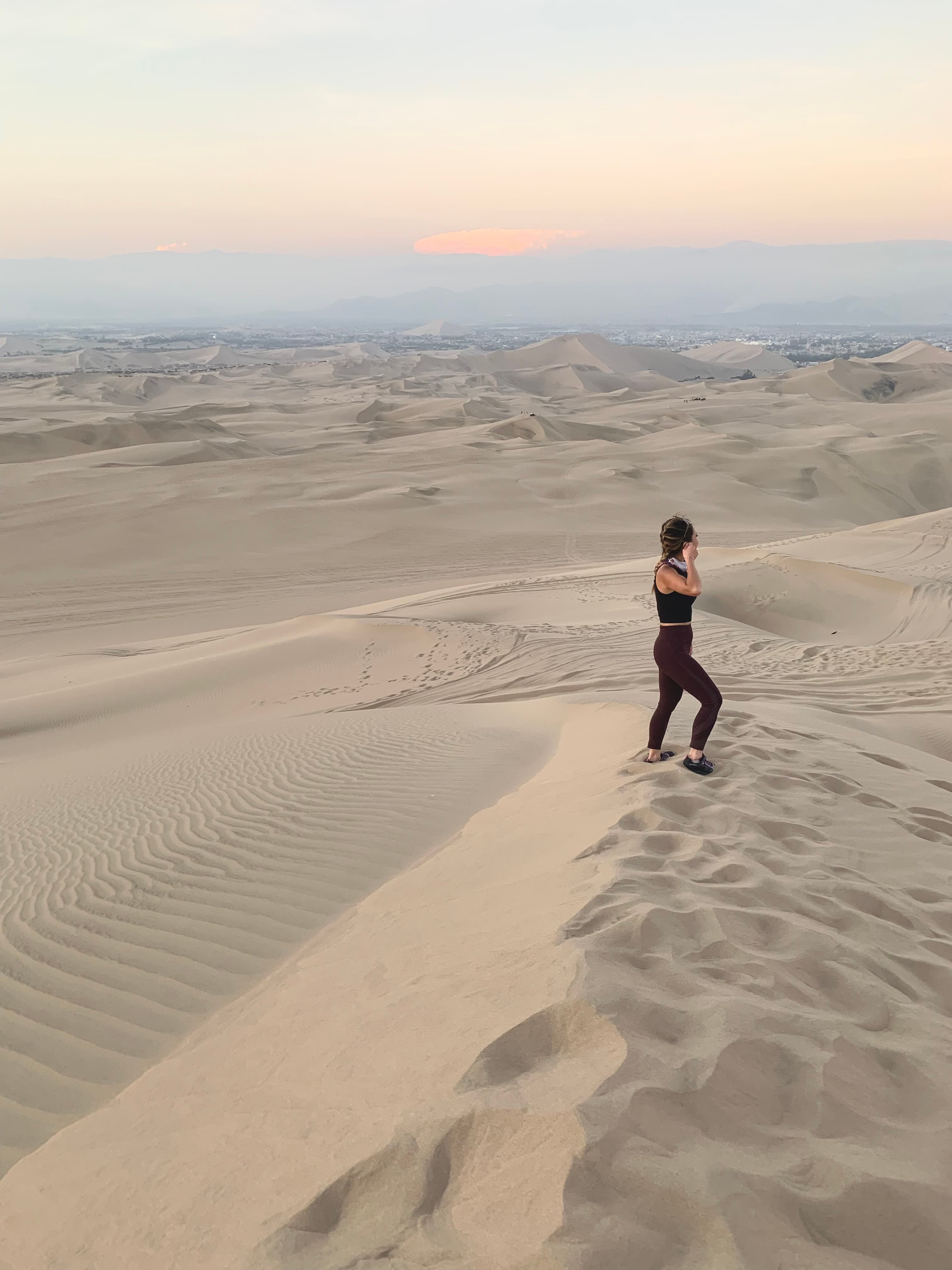 Travel advisor Truc standing in the middle of the desert at sunset