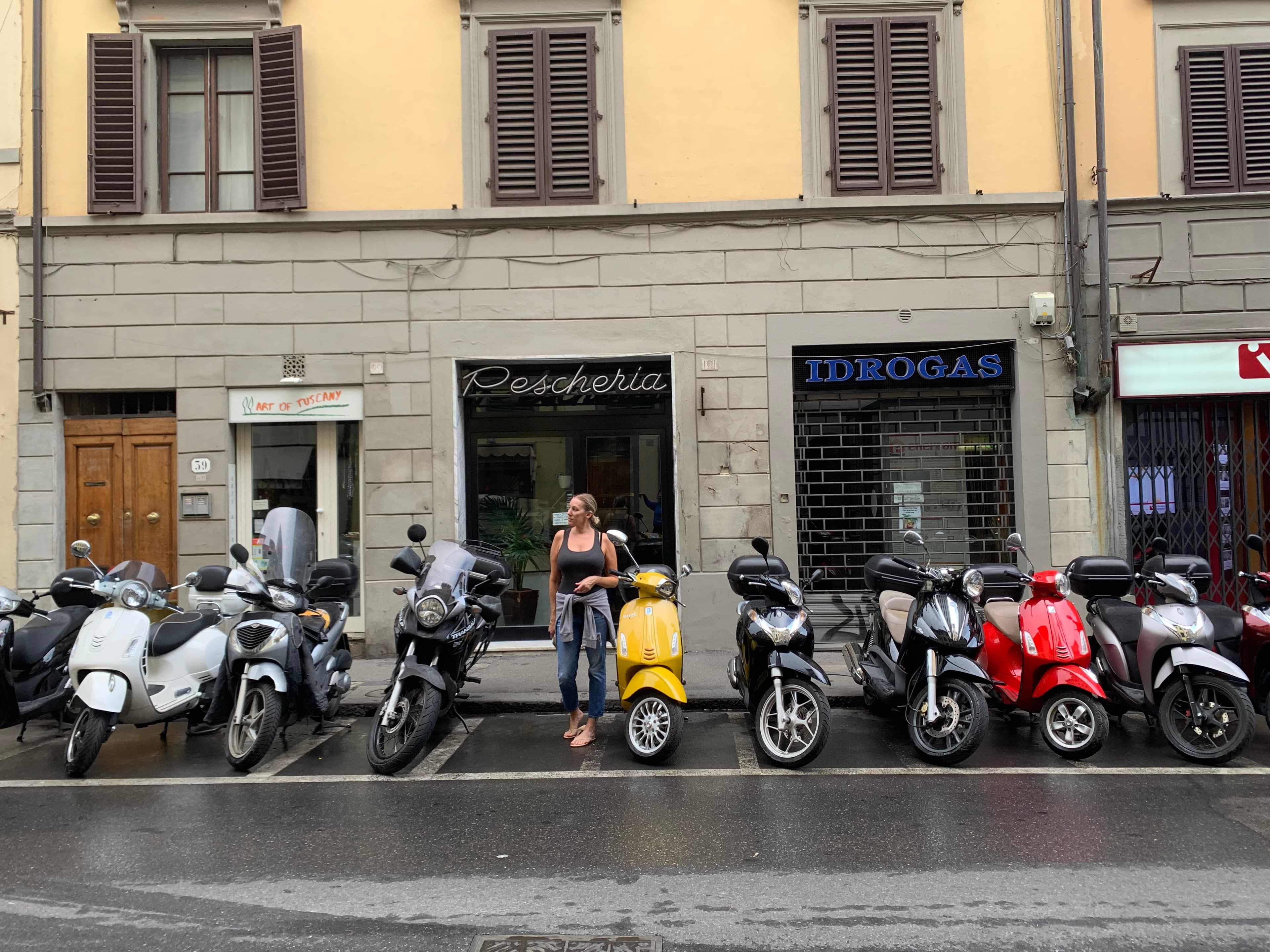 Travel advisor Jennifer standing on the street outside a yellow and brown building next to a row of vespas