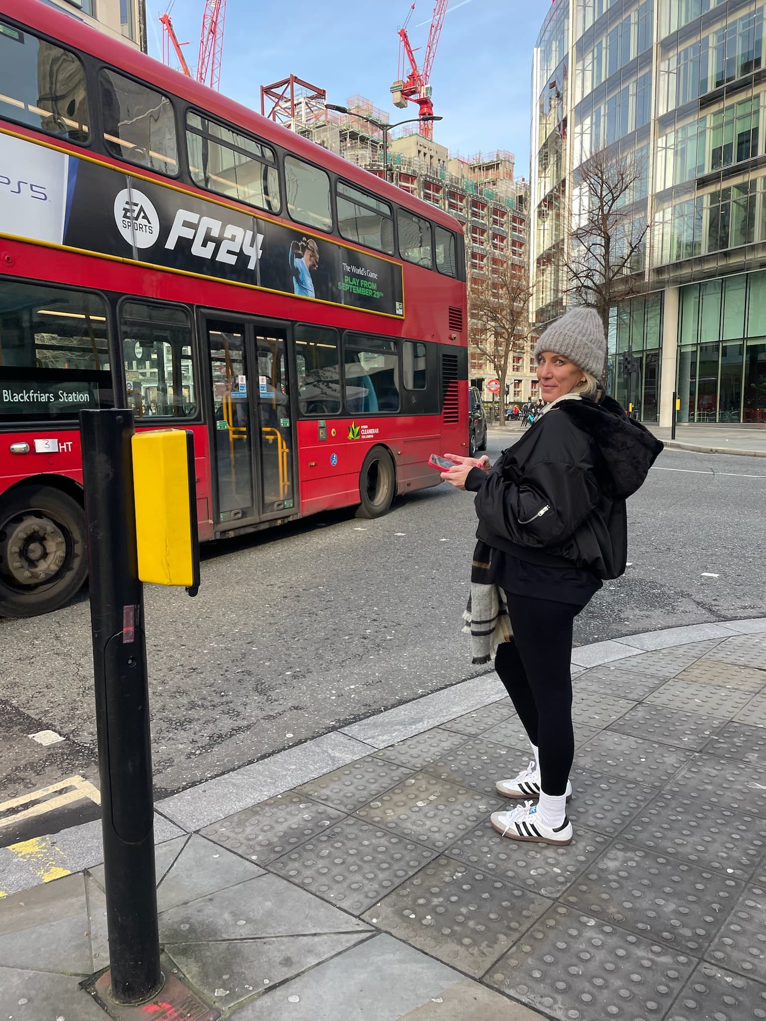 Travel advisor Jennifer standing on a sidewalk with a double decker red bus in view
