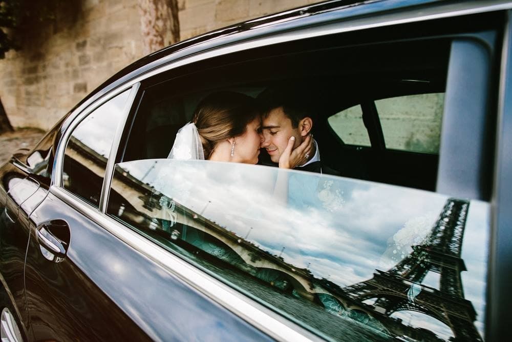 View of Natalie in a car with the Eiffel tower reflecting on the car window.