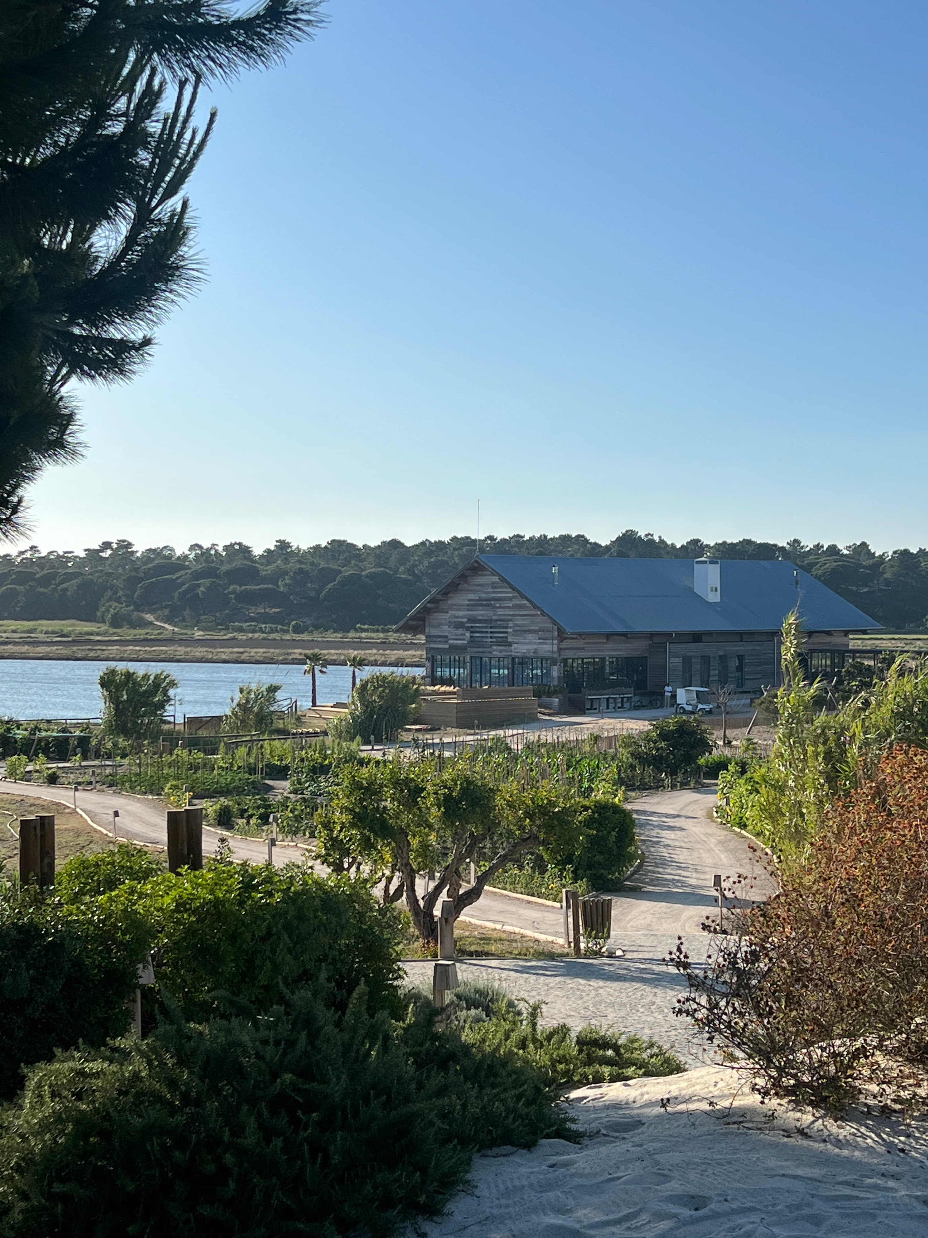 Beautiful view of a lakeside hotel with pathways, gardens and water