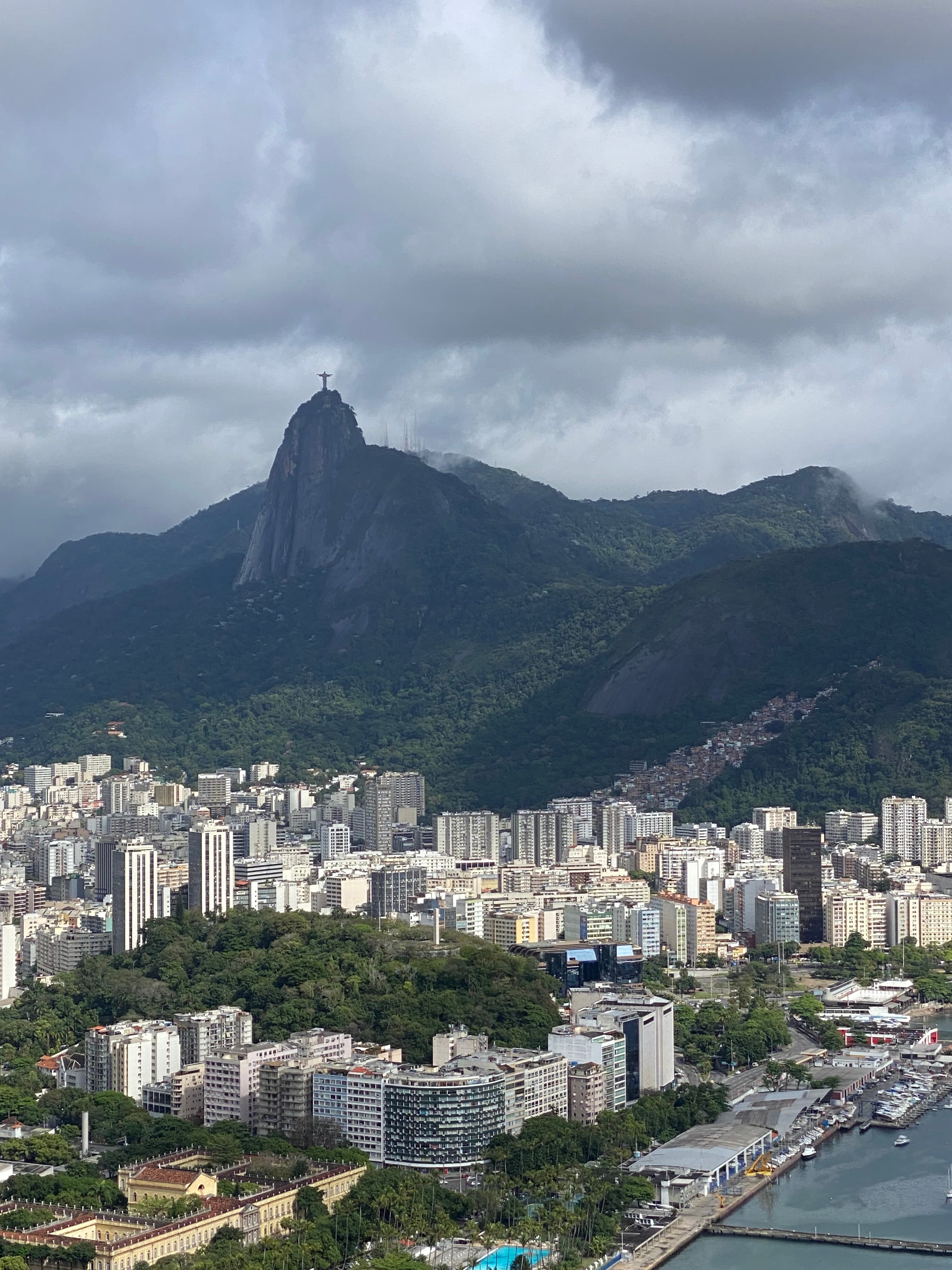 Aerial view of a city at the foothills of a green valley and mountain scape.