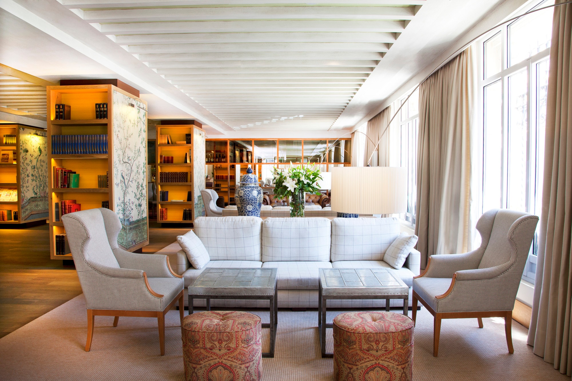 a serene hotel lobby with colorful seating cushions and a grey couch and chairs
