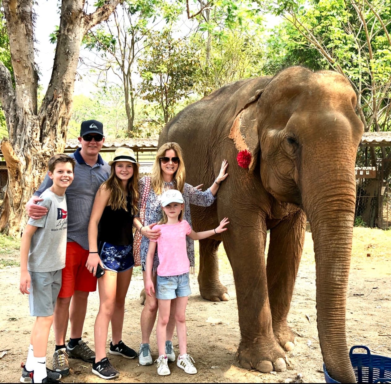 Ashley and her family standing with an elephant in an elephant sanctuary.
